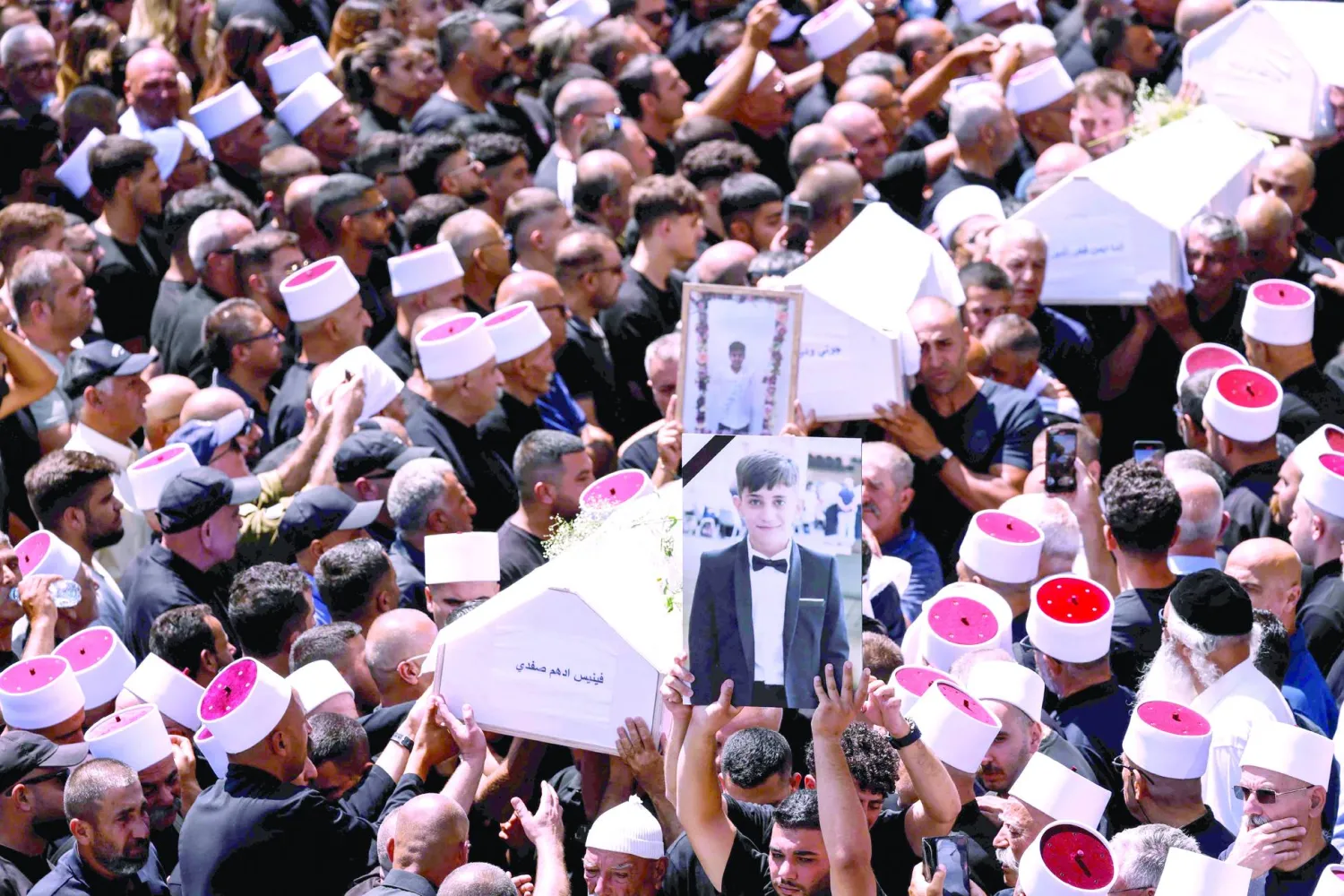 
من جنازة ضحايا الضربة الصاروخية في مجدل شمس بالجولان (أ.ف.ب)