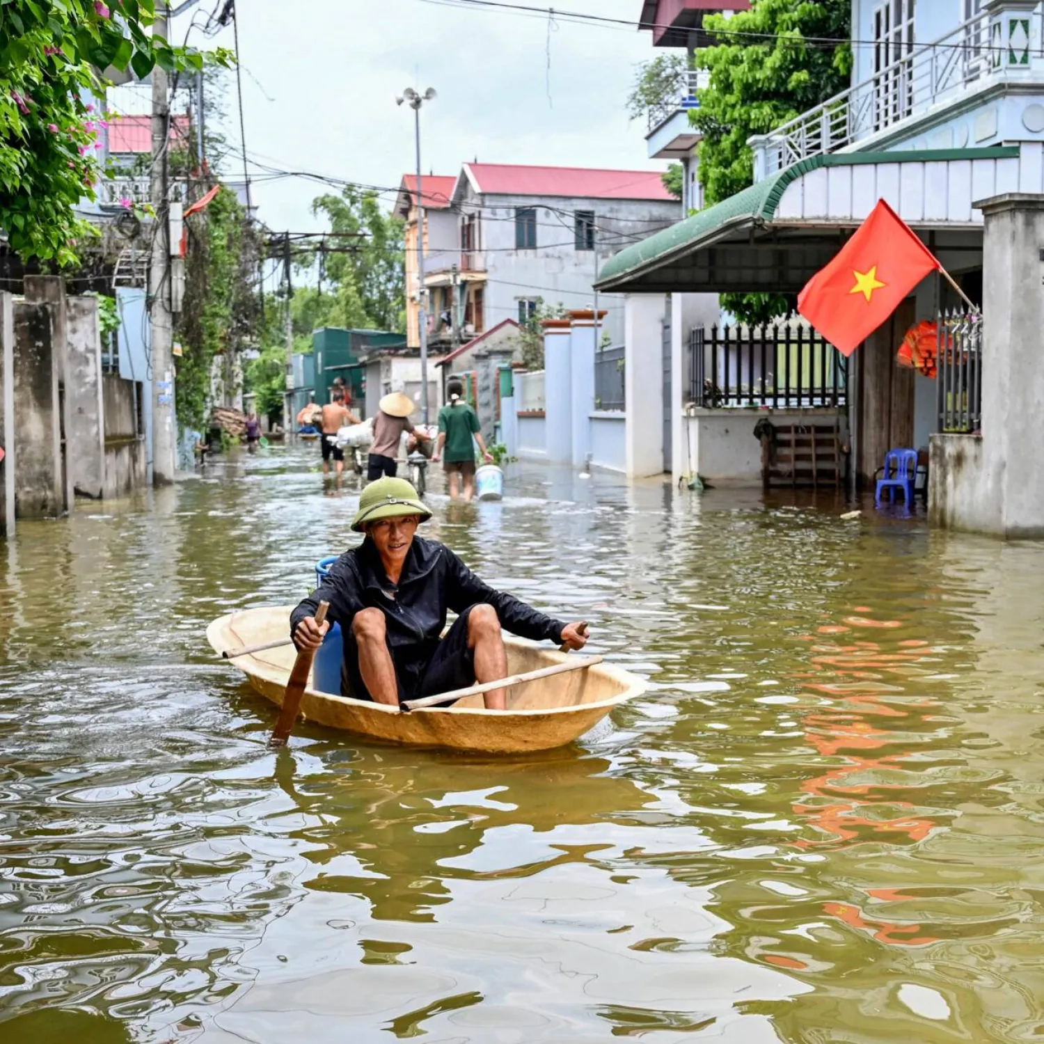 A man rowing a boat through floodwaters in Ben Voi village on the outskirts of Hanoi on July 28. Nhac NGUYEN / AFP