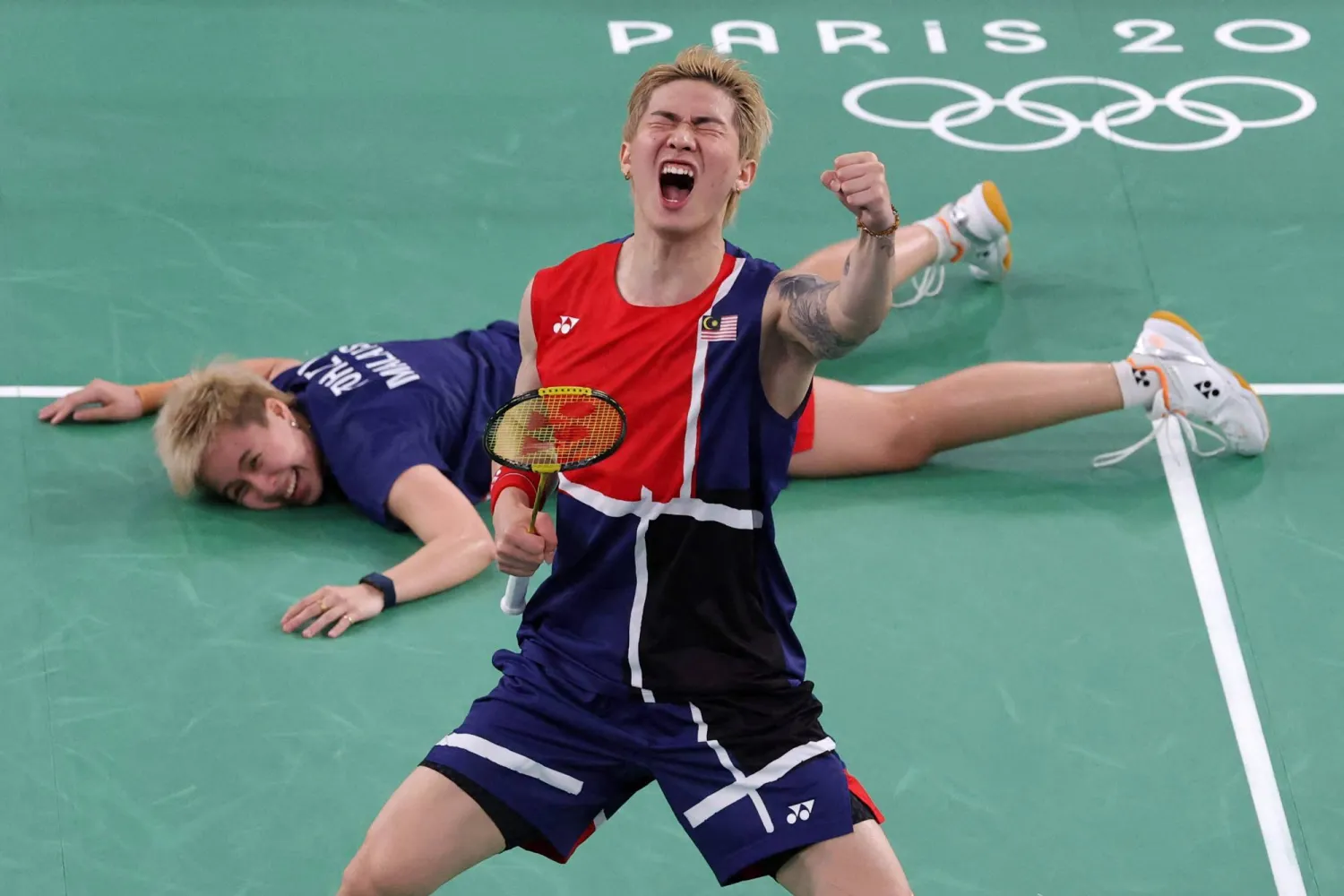 الماليزيان يحتفلان بفوزهما في دور مجموعات الريشة الطائرة ضد الصين (أ.ف.ب)