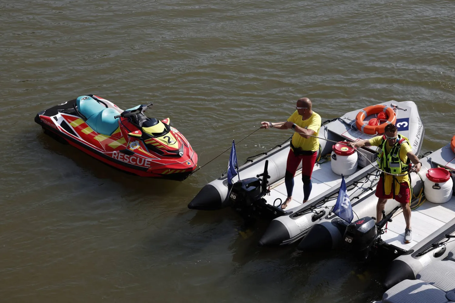 Paris 2024 Olympics - Triathlon - Alexander III Bridge, Paris, France - July 29, 2024. Workers are seen on boats after Triathlon training was cancelled amid water quality concerns. REUTERS/Benoit Tessier