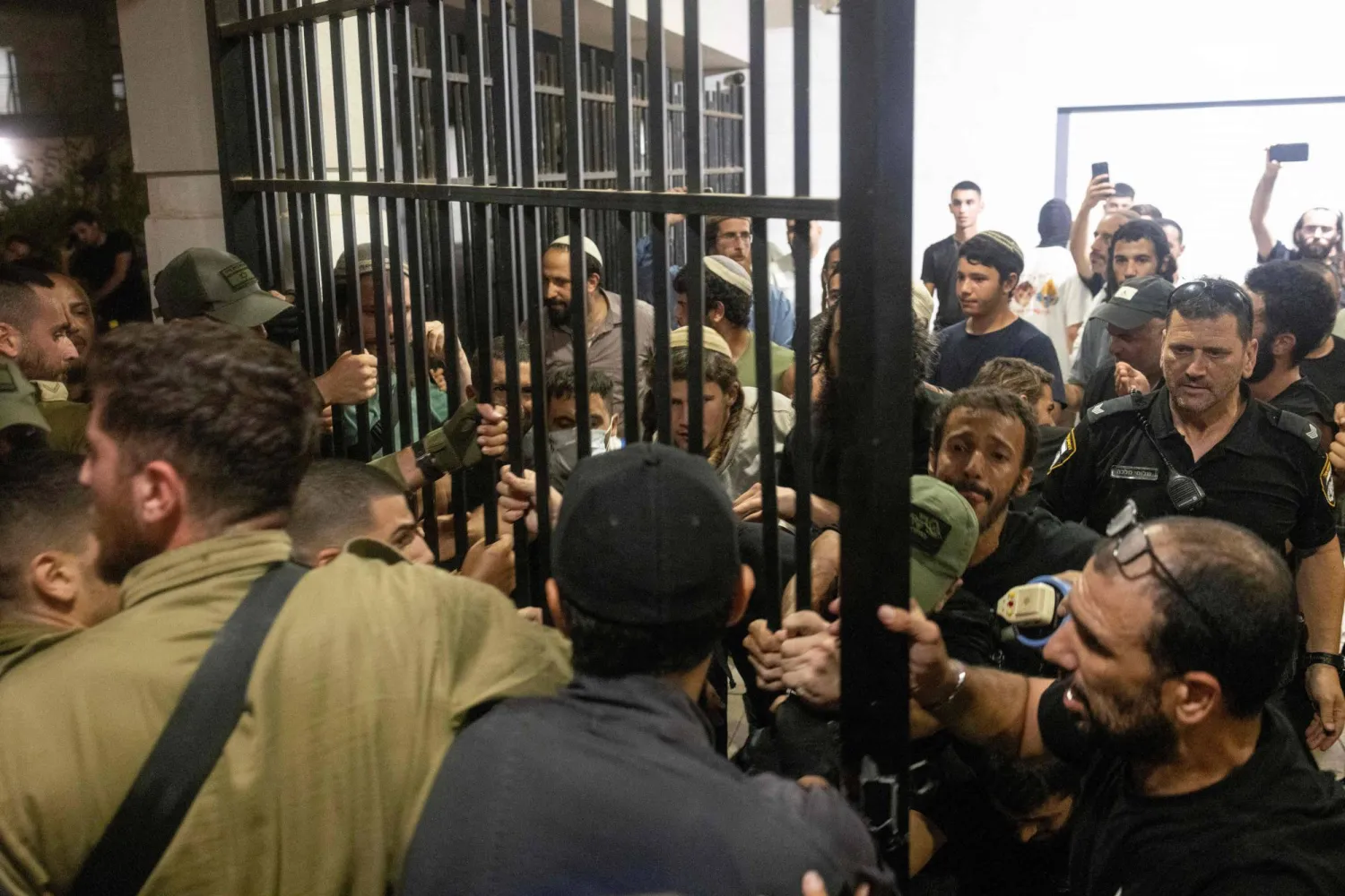 اشتبك جنود إسرائيليون مع متظاهرين من اليمين بعد اقتحامهم قاعدة «بيت ليد» العسكرية بسبب احتجاز جنود احتياطيين للتحقيق معهم للاشتباه في إساءة معاملتهم لمعتقل من «حماس» بعد هجوم 7 أكتوبر (أ.ف.ب)