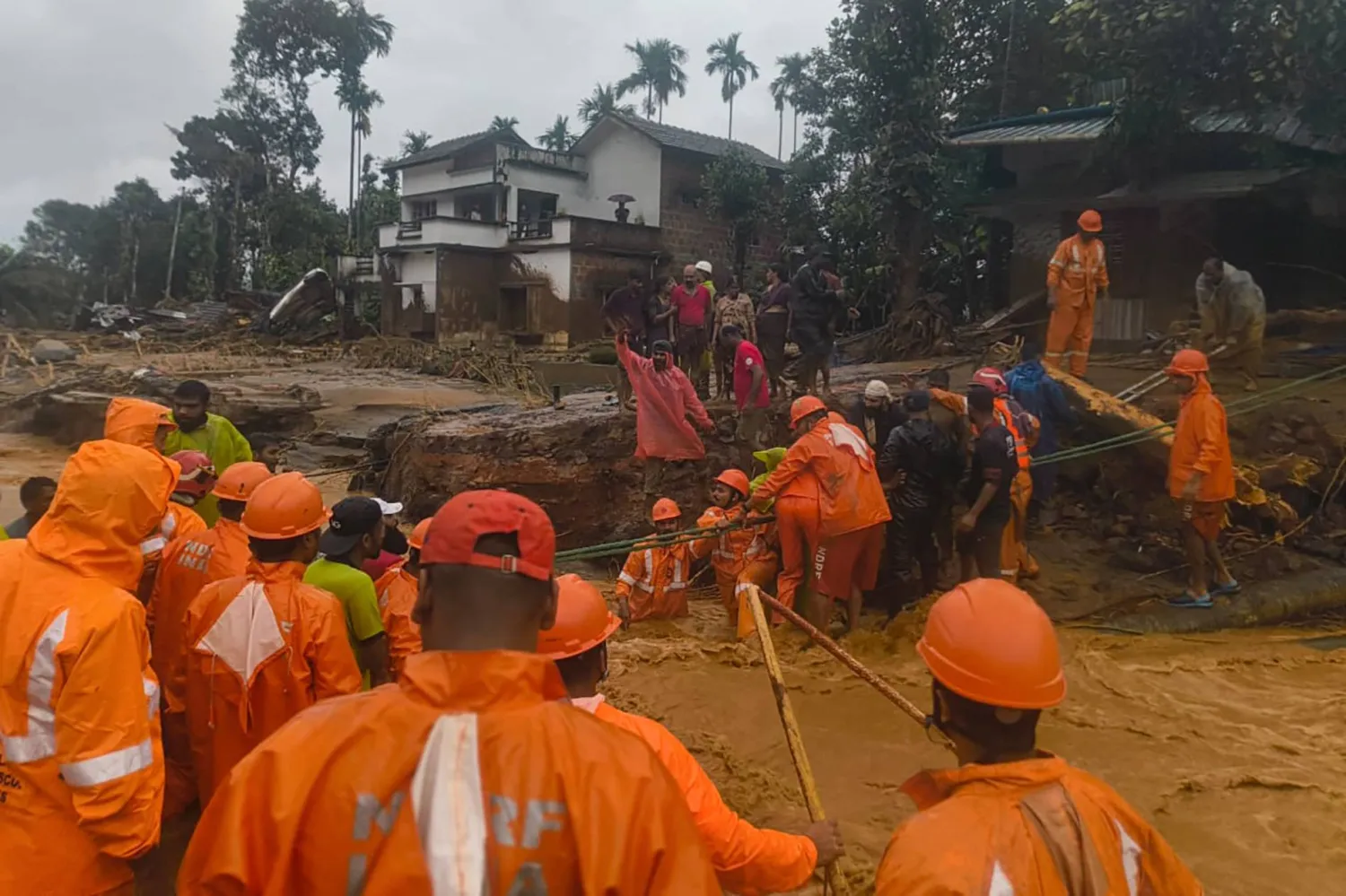 This handout photograph taken on July 30, 2024 and released by India's National Disaster Response Force (NDRF) shows NDRF personnel at the disaster site as they rescue victims of the landslide in Wayanad. (Photo by National Disaster Response Force (NDRF) / AFP)