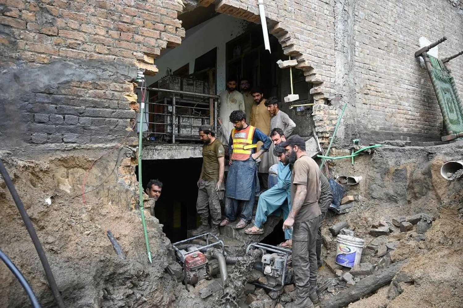 Rescue workers clean the basement of a house damaged by flash flood waters in Darra Adamkhel, Khyber Pakhtunkhwa province of Pakistan, on July 30, 2024. (AFP)