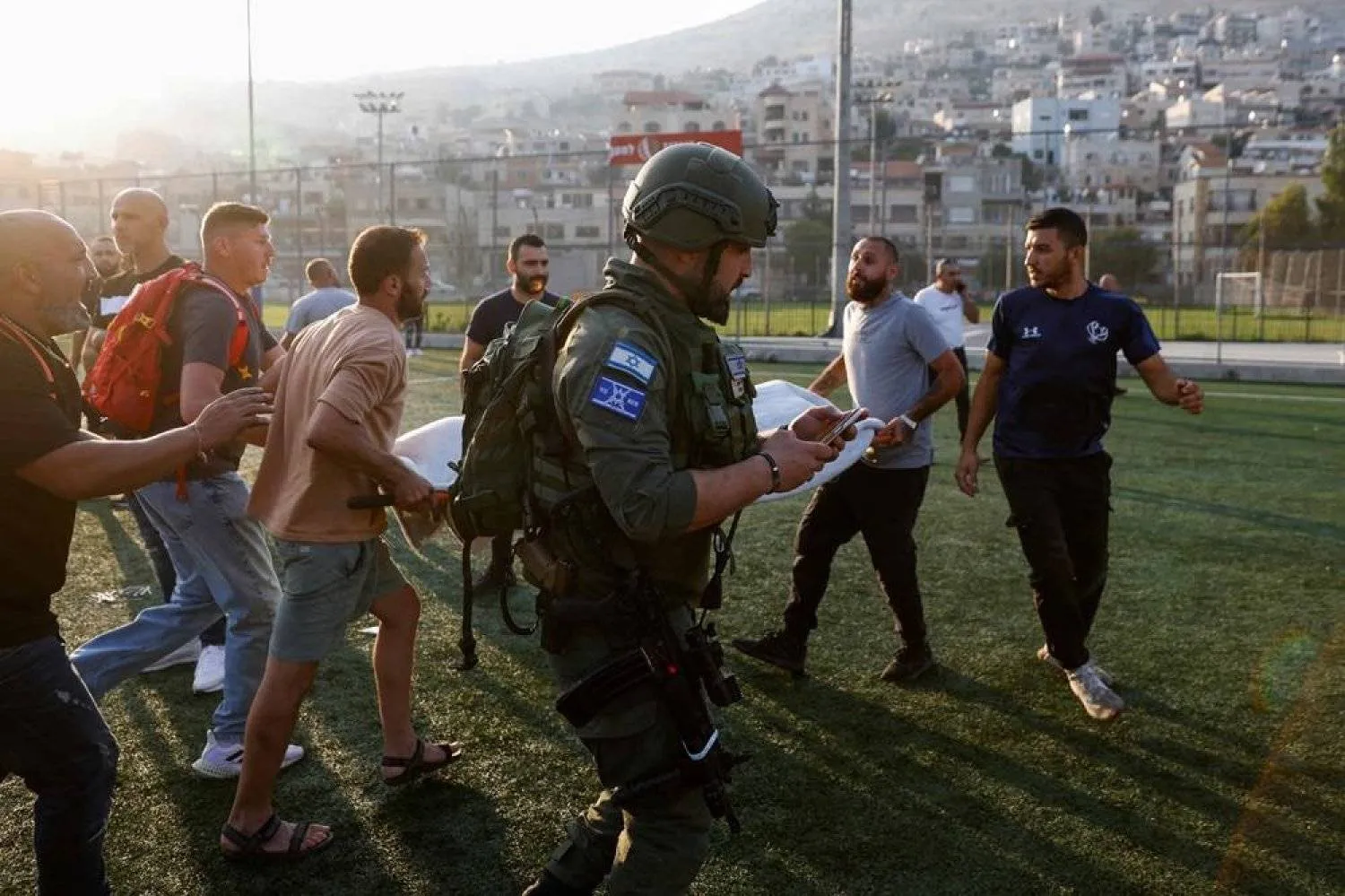 Israeli security forces and medics transport casualties from a site where a reported strike from Lebanon fell in Majdal Shams village in the Israeli-annexed Golan area on July 27, 2024. (AFP)
