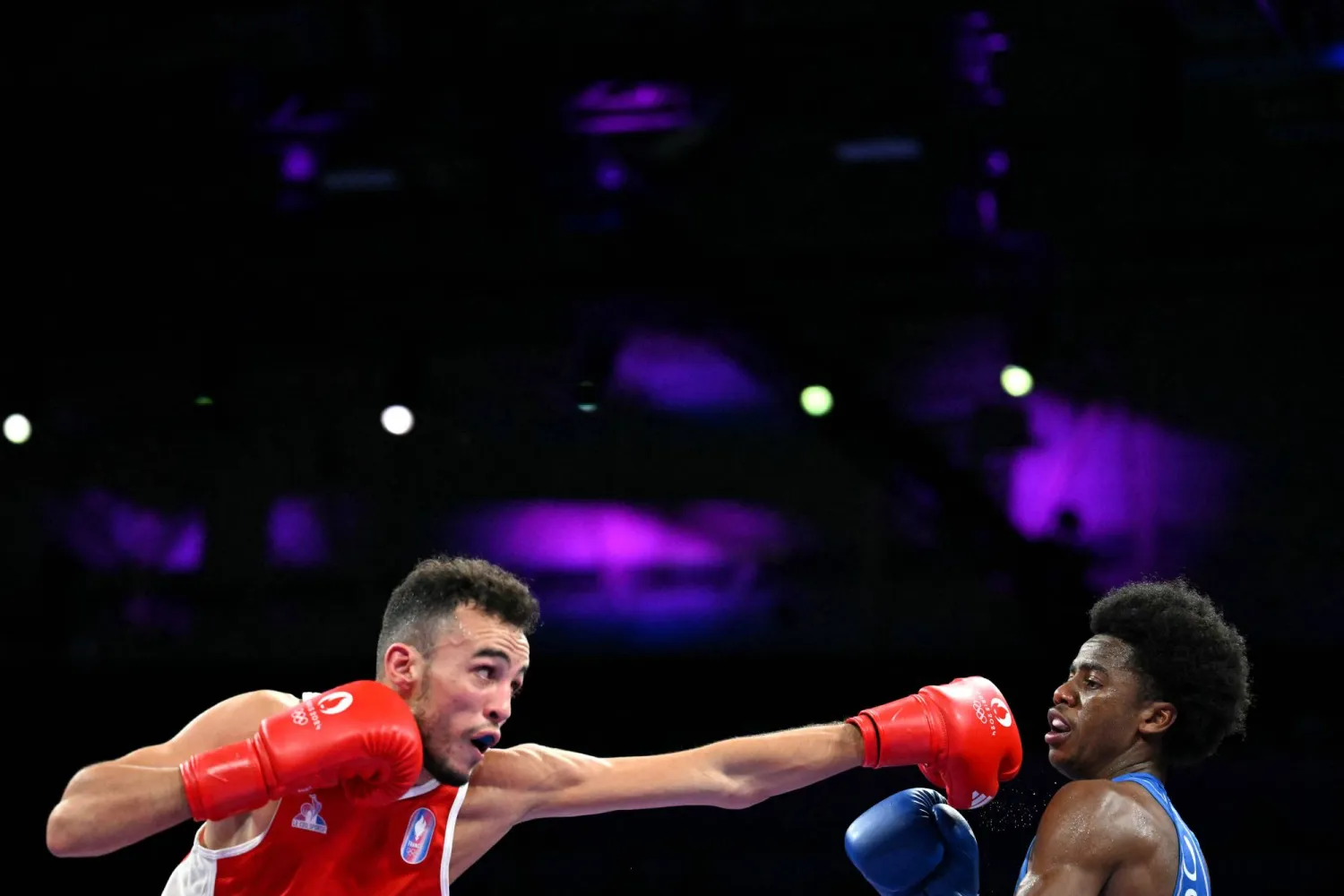 بلال بن نعمة يسدد لكمة قوية لمنافسه الأميركي خلال نزال وزن الذبابة في الأولمبياد (أ.ف.ب)