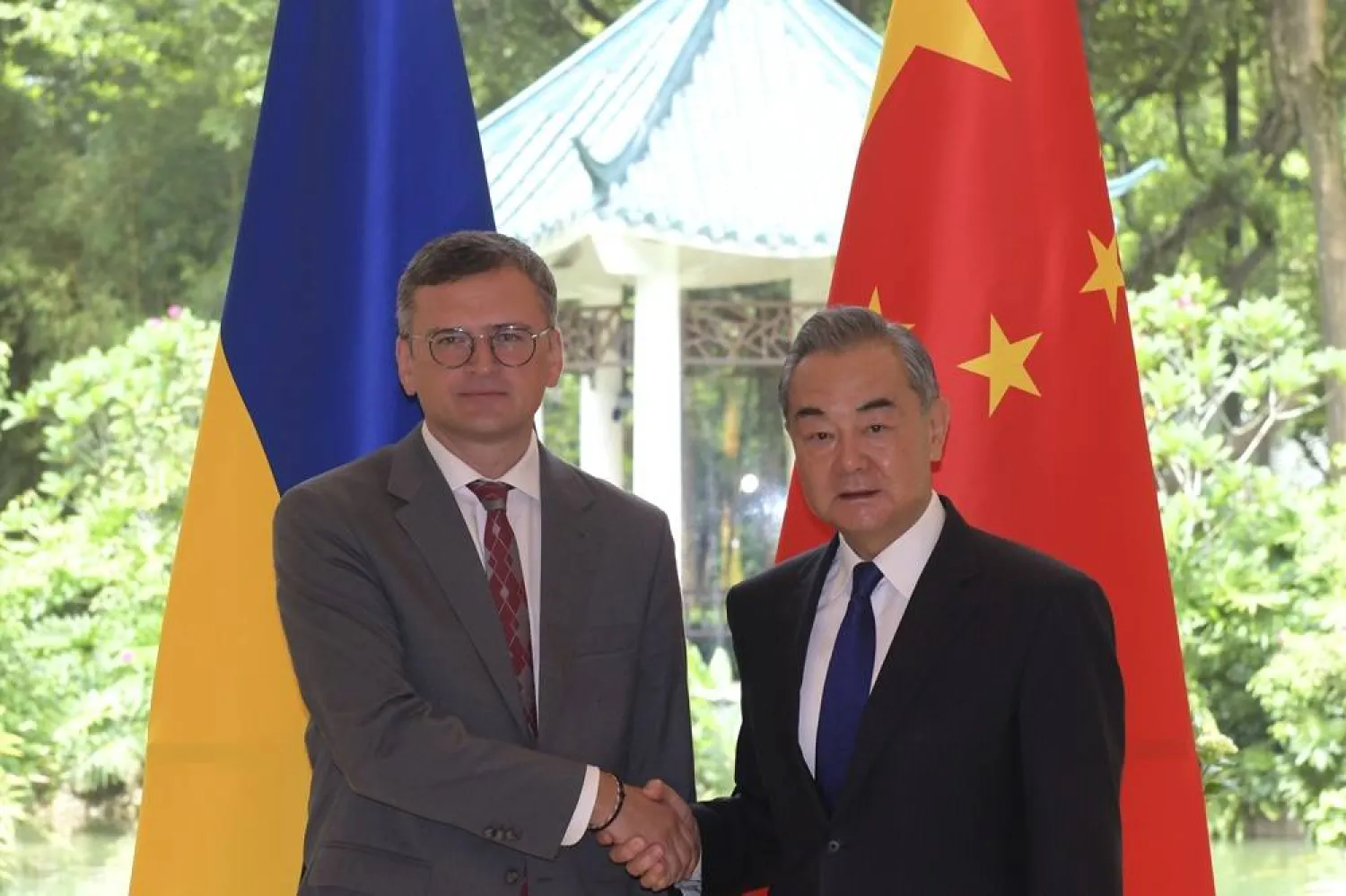 In this photo released by Xinhua News Agency, Ukraine's Foreign Ministry Dmytro Kuleba, left, poses for photos with China's Foreign Minister Wang Yi before a meeting in the southern Chinese city of Guangzhou on Wednesday, July 24, 2024. (Lu Hanxin/Xinhua via AP) 