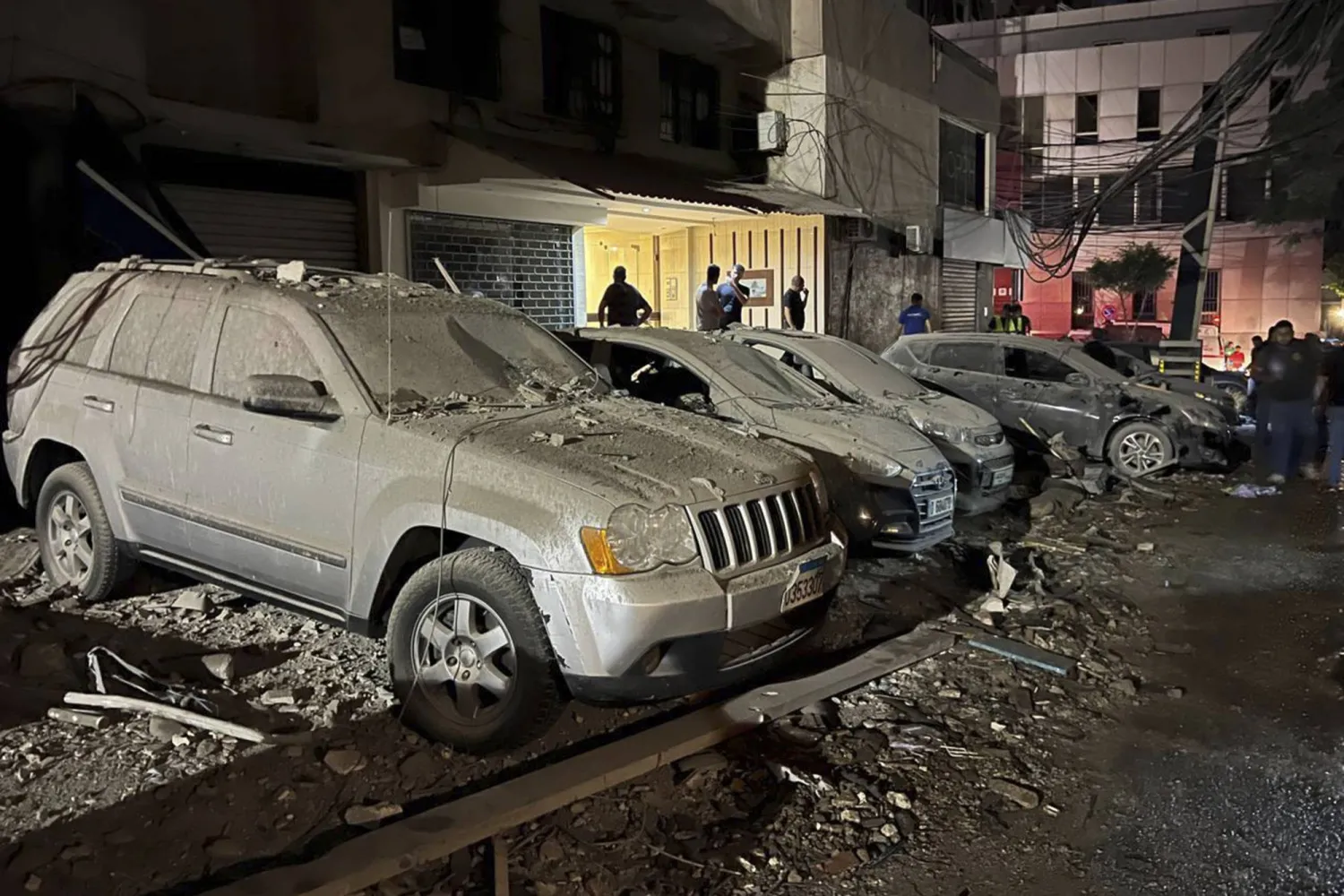أشخاص يتفقدون السيارات المتضررة جراء الغارة الإسرائيلية التي استهدفت قيادياً في "حزب الله" في الضاحية الجنوبية لبيروت، لبنان، الثلاثاء 30 يوليو 2024 (أ.ب)