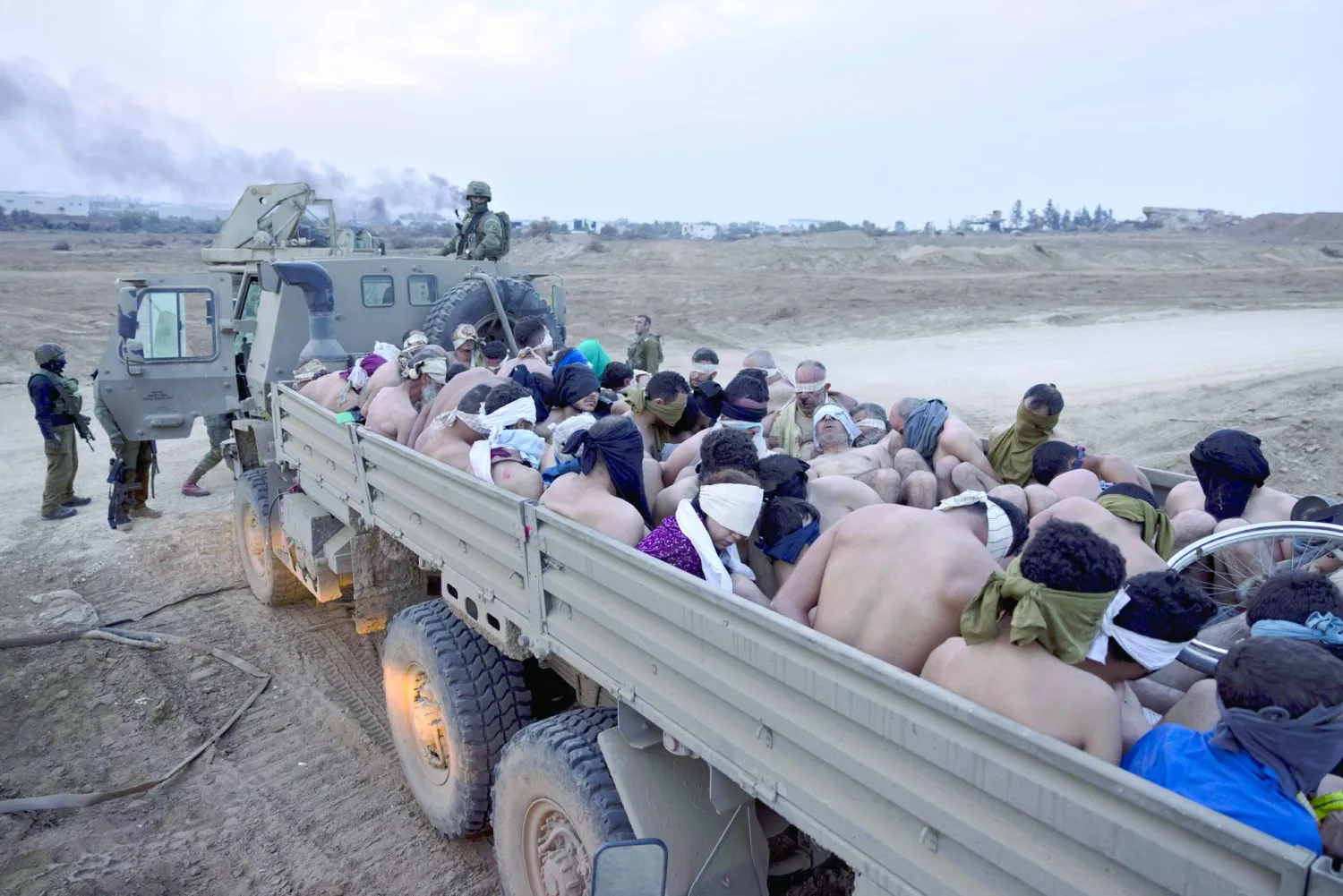 FILE - Israeli soldiers stand by a truck packed with bound and blindfolded Palestinian detainees, in Gaza on Dec. 8, 2023. (AP Photo/Moti Milrod, Haaretz, File)