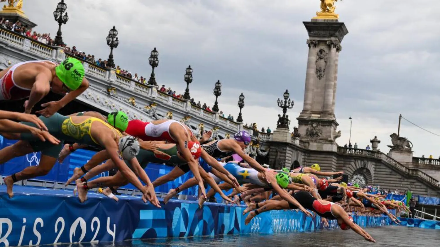Triathletes dive into the River Seine at the start of the Olympic triathlon. Jeff PACHOUD / AFP
