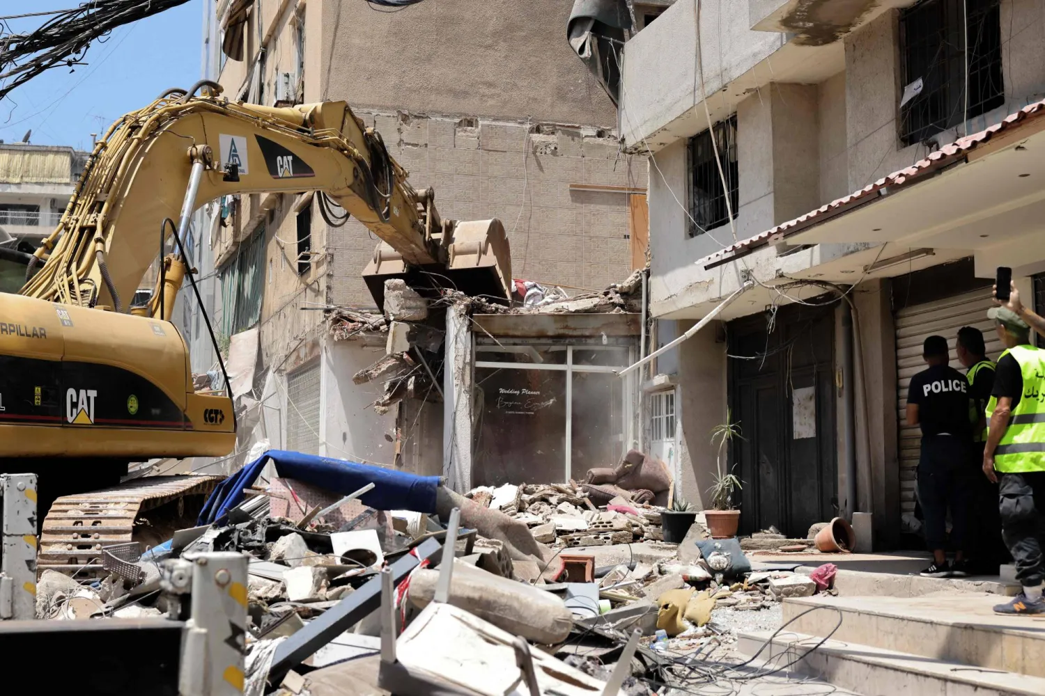 جرار يزيل الحطام بعد يوم واحد من قصف الجيش الإسرائيلي لمبنى في الضاحية الجنوبية لبيروت (أ.ف.ب)