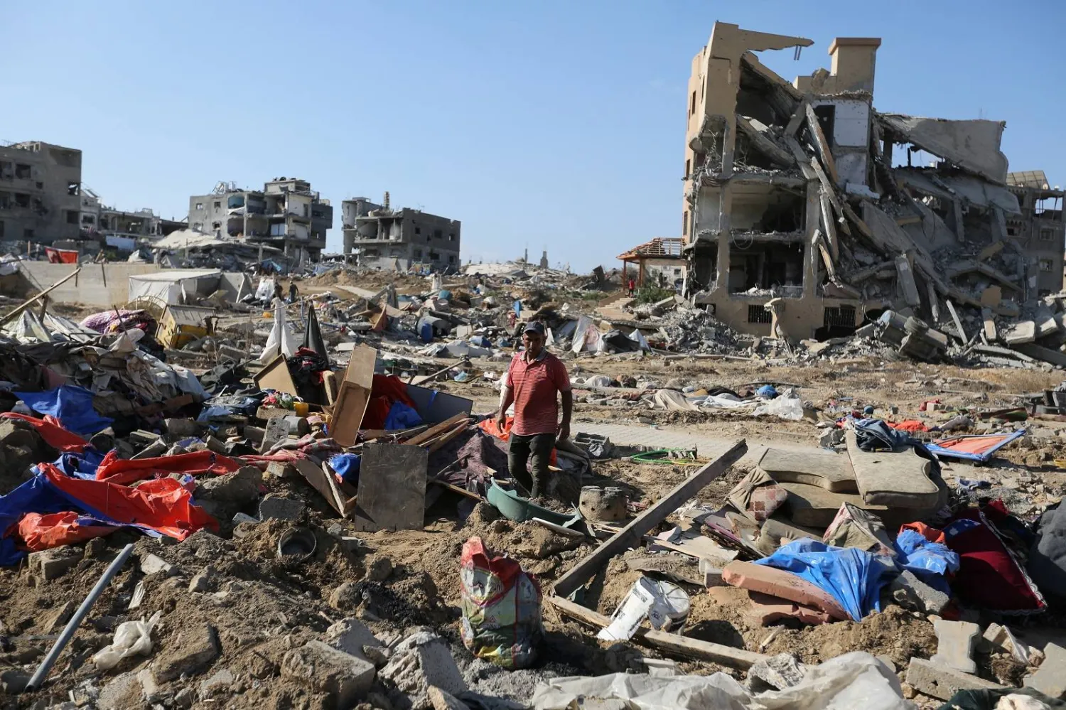 رجل فلسطيني يخطو بين الأنقاض عقب غارة إسرائيلية على خان يونس (رويترز)