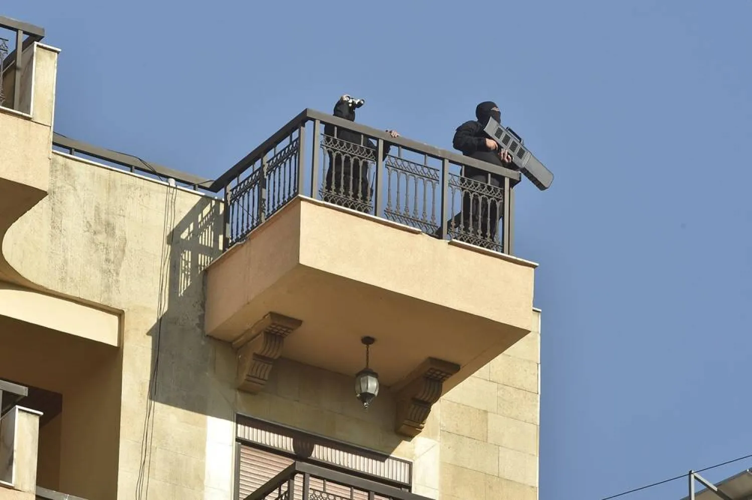 Armed men keep watch atop a building during the funeral procession of late senior Hezbollah commander Fuad Shukr, killed in an Israeli strike, in Beirut, Lebanon, 01 August 2024. (EPA) 