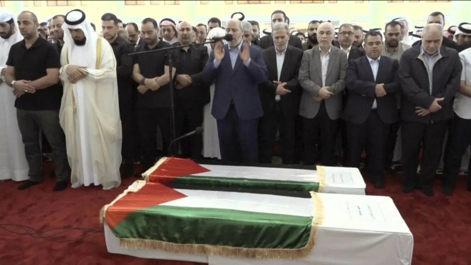 This video grab shows senior Hamas official Khalil al-Hayya, center, praying near the coffin of Hamas leader Ismail Haniyeh and his bodyguard during the funeral prayers in Doha, Qatar, Friday Aug. 2, 2024. (The AP)
