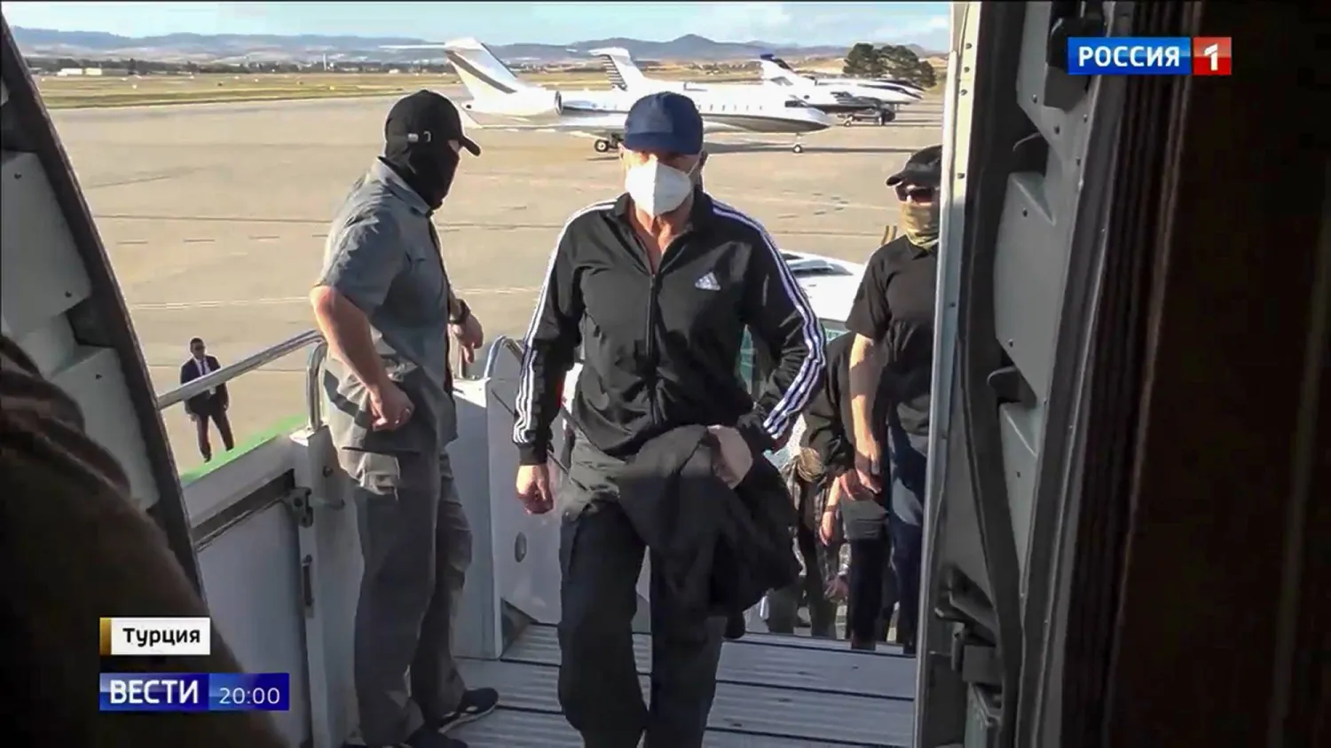 عنصر جهاز الأمن الفيدرالي الروسي فاديم كراسيكوف خلال صعوده إلى طائرة في أنقرة بعد الإفراج عنه في إطار صفقة تبادل كبيرة مع موسكو (أ.ب)