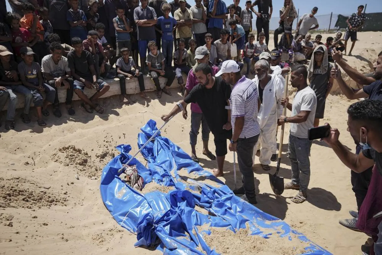 A man checks a body returned by Israel, before burial in a cemetery in Khan Younis, Gaza Strip, Monday, Aug. 5, 2024. (AP)