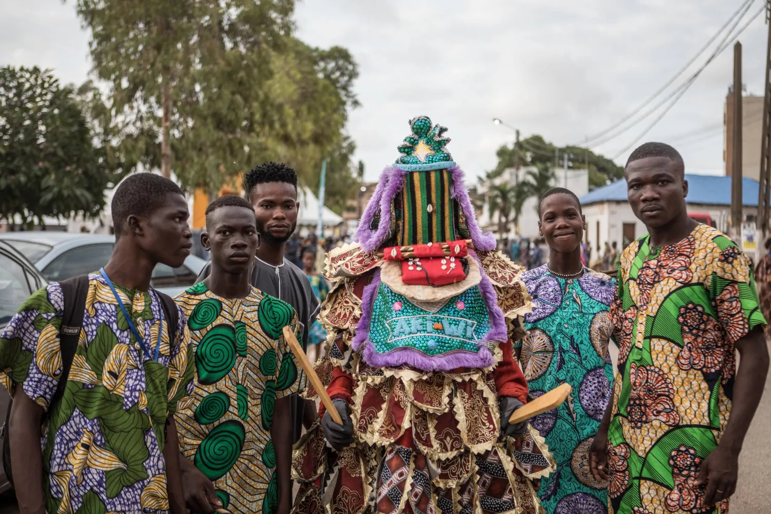 Paradegoers pose with an egungun, a traditional Yoruba figure, at the Porto Novo Mask Festival. Yanick Folly / AFP
