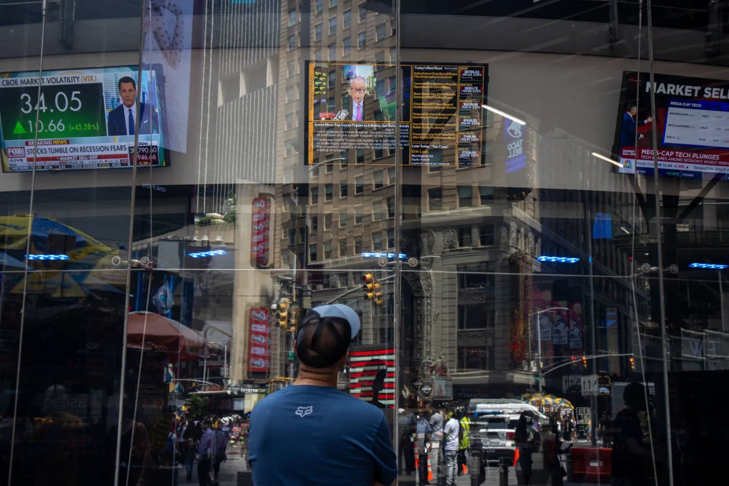 أشخاص يمرون أمام مؤشر «ناسداك» في نيويورك (وكالة حماية البيئة)