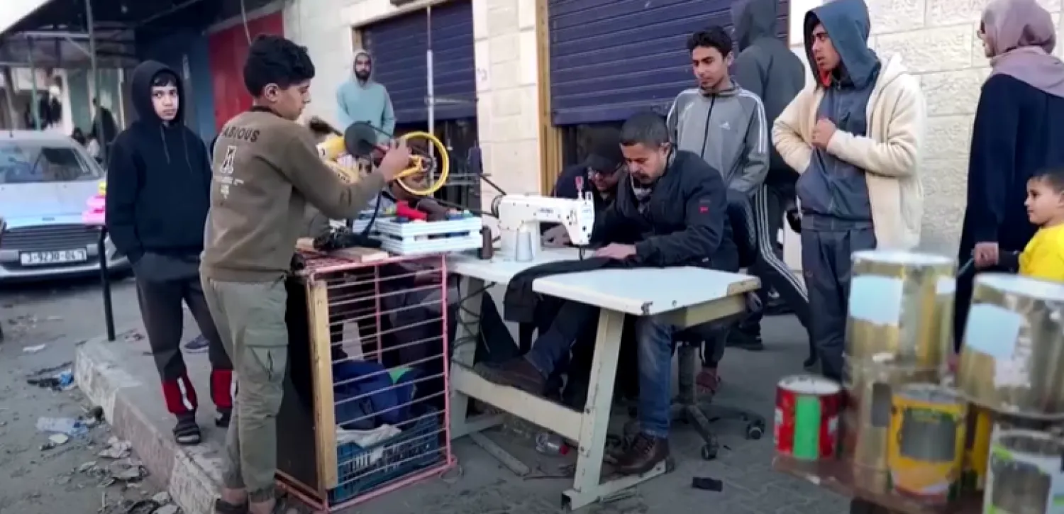 Raad Saad powers his sewing machine in the ruins of his factory as the conflict between Israel and the Palestinian group Hamas rages (Photo grab from Reuters video) 