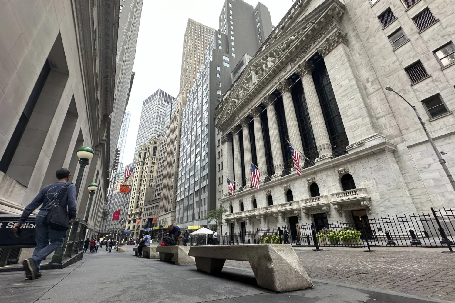 FILE - People pass the New York Stock Exchange on July 30, 2024 in New York. (AP Photo/Peter Morgan, File)