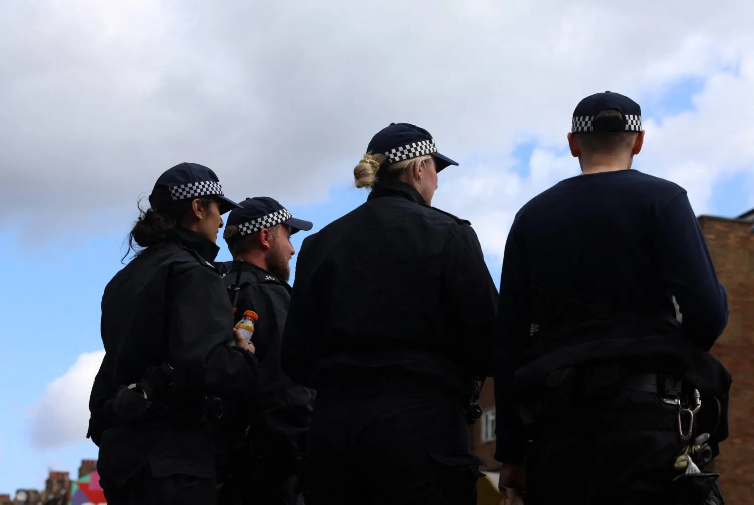 Police officers stand guard as protective measures against damage from riots are implemented, in preparation for more unrest amidst anti-immigration related rioting across the country, in London, Britain, August 7, 2024. REUTERS/Mina Kim