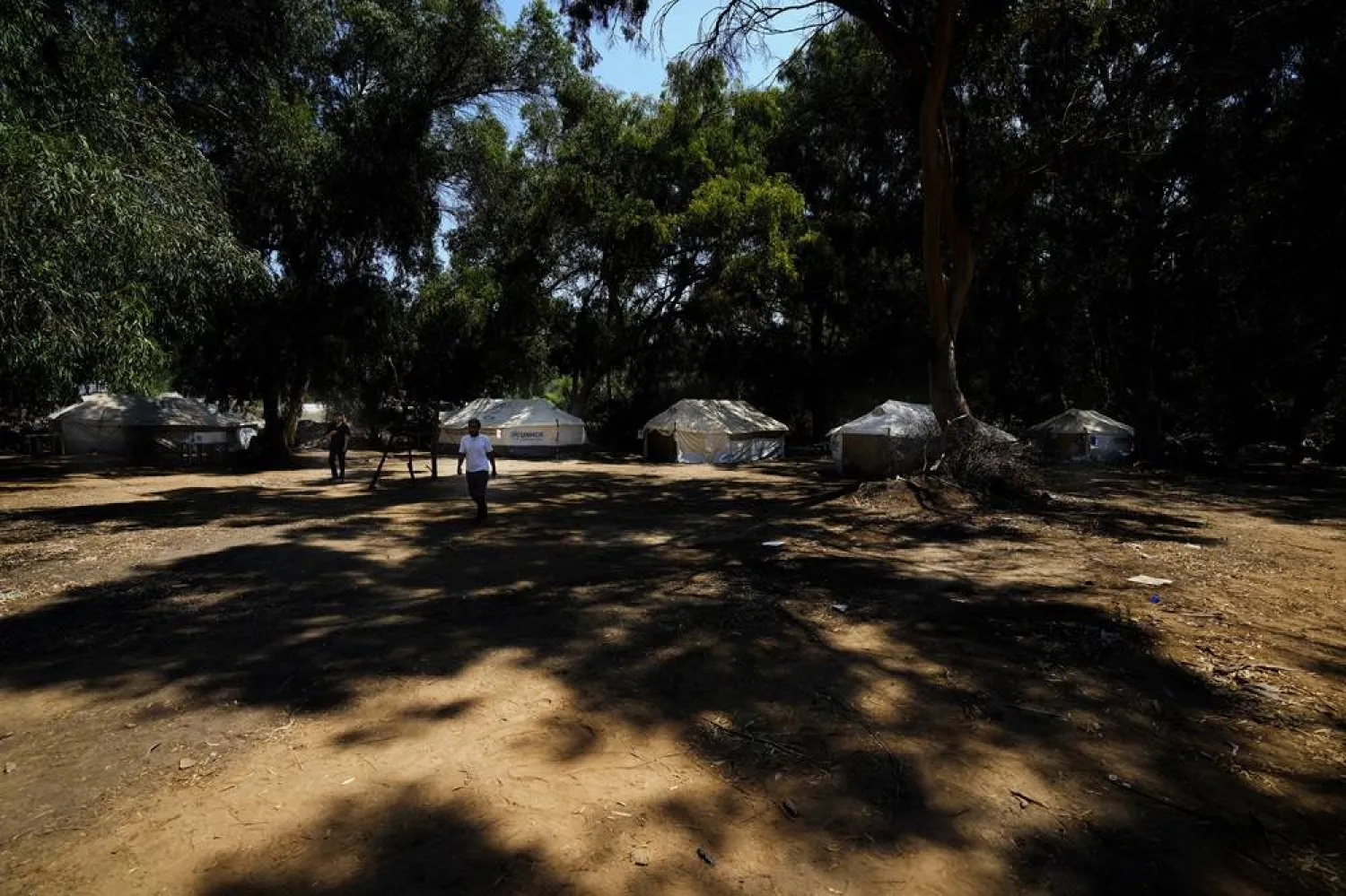  Men walk at a camp inside the UN controlled buffer zone that divide the north part of the Turkish occupied area from the south Greek Cypriots at Aglantzia area in the divided capital Nicosia, Cyprus, Friday, Aug, 9, 2024. (AP) 