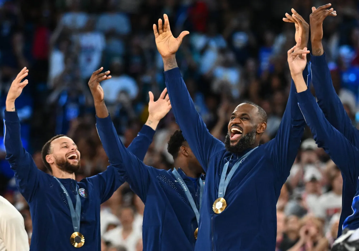 Gold medallists USA's #04 Stephen Curry (L), USA's #06 LeBron James and teammates celebrate on the podium after the men's Gold Medal basketball match between France and USA during the Paris 2024 Olympic Games at the Bercy  Arena in Paris on August 10, 2024. (Photo by Aris MESSINIS / AFP)