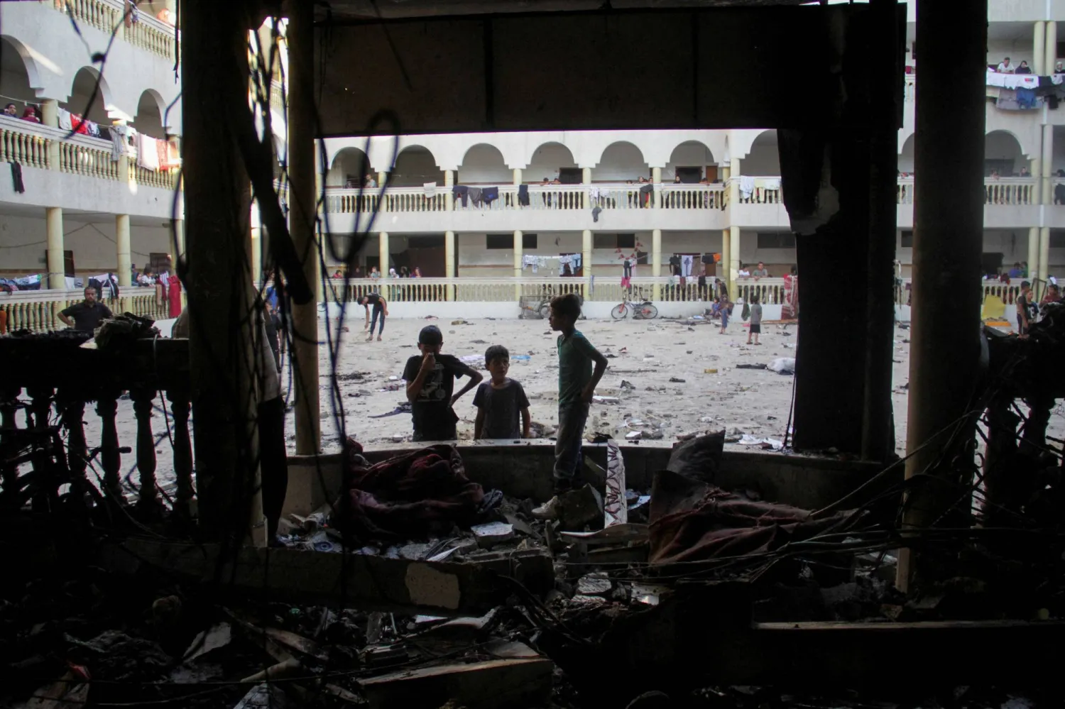 Palestinians look at the damage at the site of an Israeli strike on a school sheltering displaced people, amid the Israel-Hamas conflict, in Gaza City August 10, 2024. REUTERS/Mahmoud Issa 