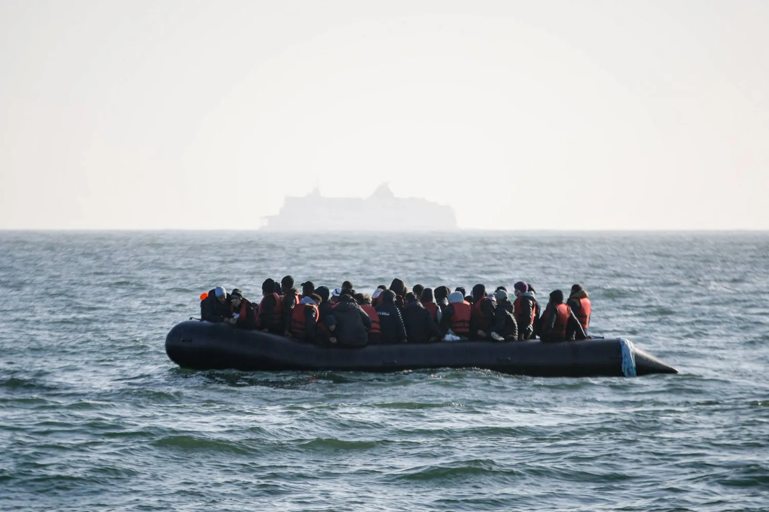 Migrants wait for help from the Abeille Languedoc ship after their boat's generator broke down in French waters while they were trying to cross the Channel illegally to Britain, off the coasts of Boulogne-sur-Mer, northern France, on May 9, 2022. (Photo by Sameer Al-DOUMY / AFP)