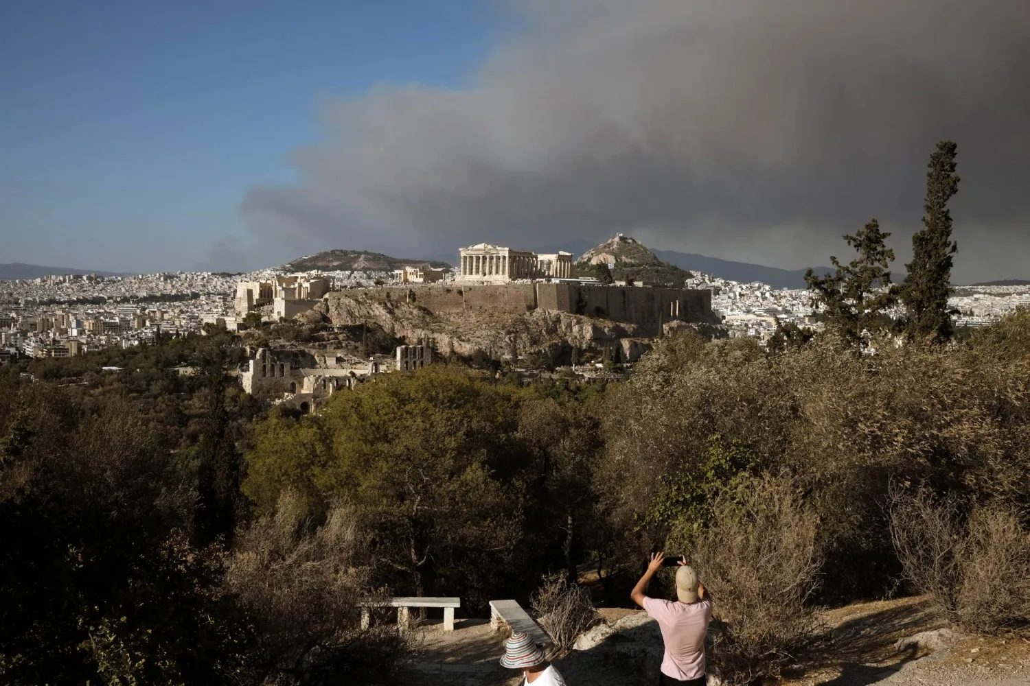 The Parthenon temple atop the Acropolis hill as smoke from a wildfire is seen in the village of Varnava blankets Athens, Greece, August 11, 2024. REUTERS/Elias Marcou