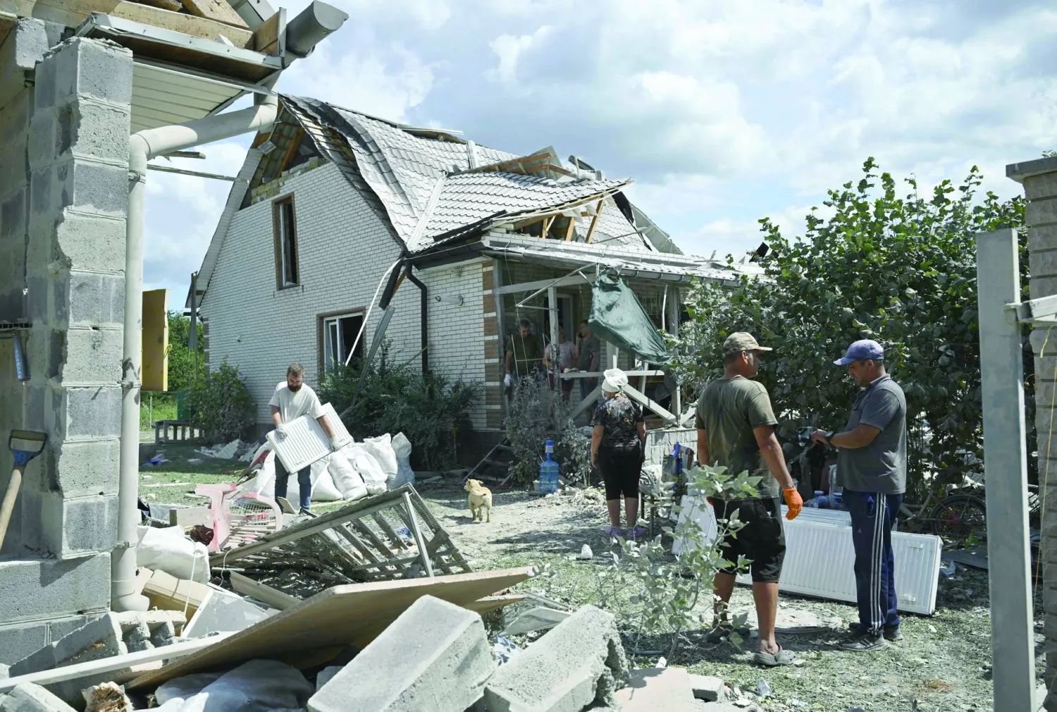 Locals save belonging from a residential house, heavily damaged following a Russian missile strike on August 11, 2024, in a village in the Brovary district, Kyiv region, amid the Russian invasion of Ukraine. (Photo by Genya SAVILOV / AFP)