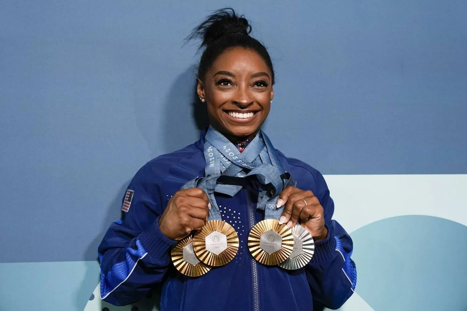 Simone Biles, of the United States, holds up her medals after the women's artistic gymnastics individual apparatus finals Bercy Arena at the 2024 Summer Olympics, Monday, Aug. 5, 2024, in Paris, France. (AP)
