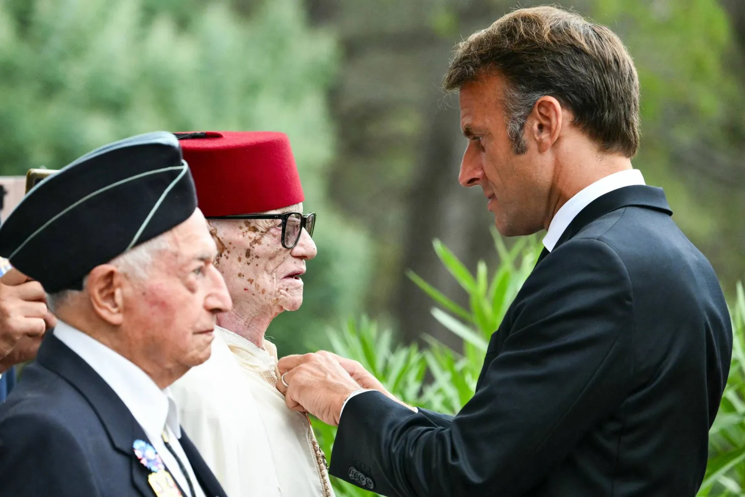 الرئيس الفرنسي يقلد الجندي المغربي العربي جوى الذي شارك في عدد من معارك الجيش الفرنسي وسام جوقة الشرف (أ.ب)