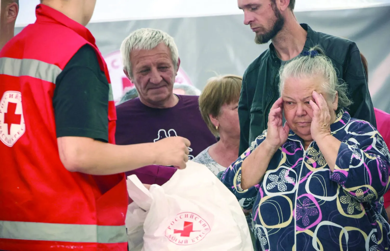 
روس شردتهم الحرب يتلقون معونة إنسانية من الصليب الأحمر الروسي في كورسك أمس (أ.ف.ب)