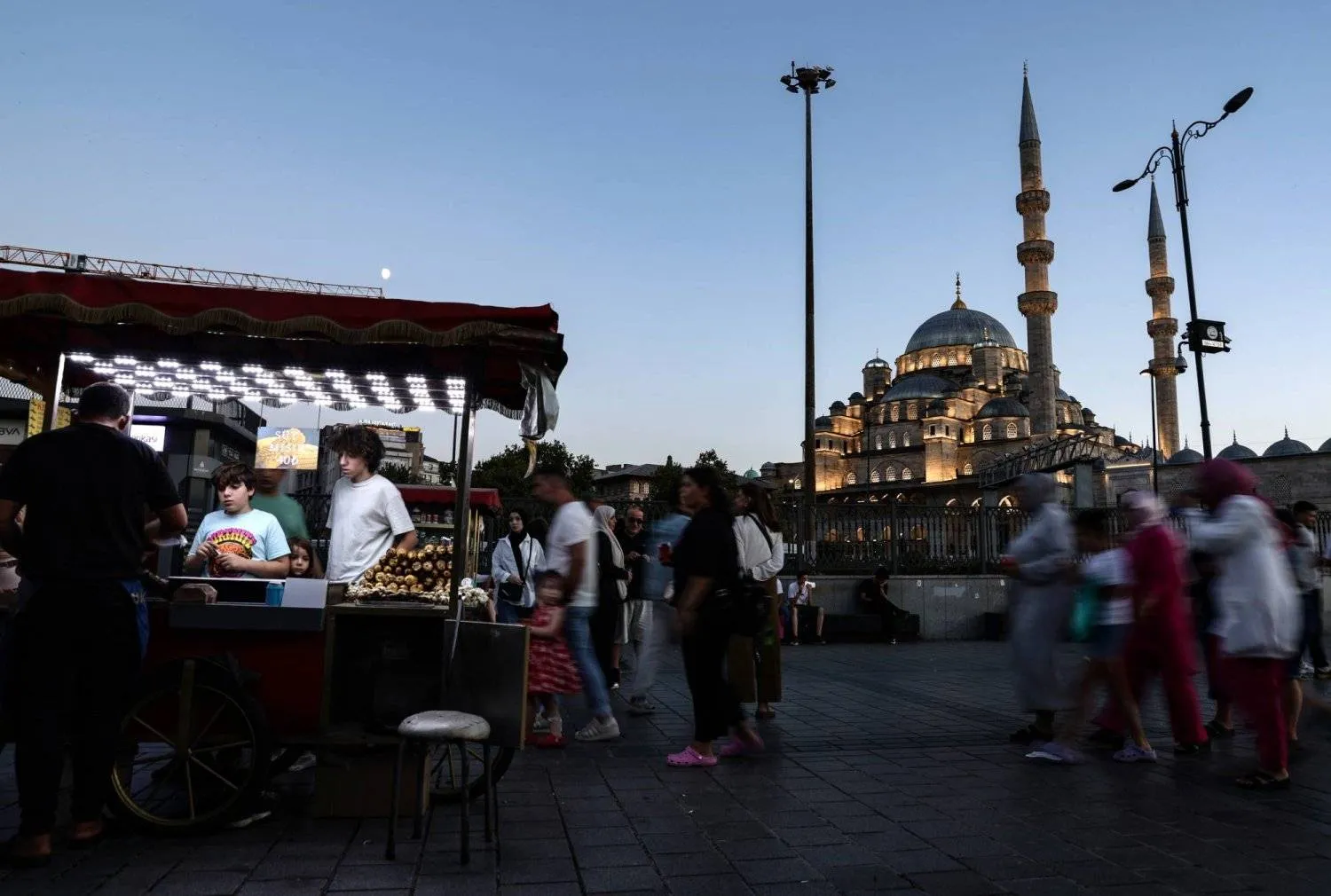 People walk in front of the Eminonu New Mosque during sunset in Istanbul, Türkiye, 15 August 2024. EPA/ERDEM SAHIN
