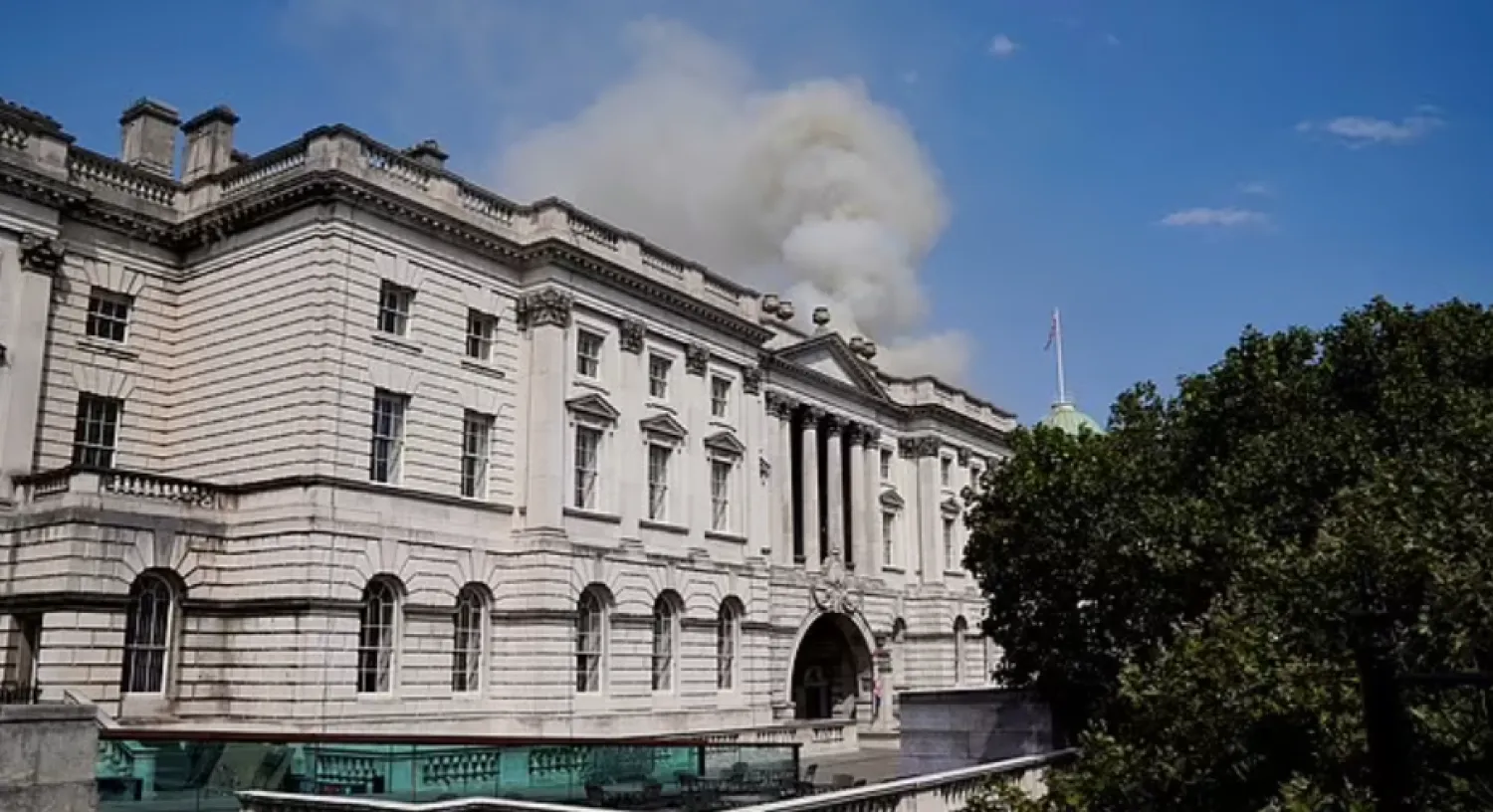 Smoke can be seen pouring from the roof of Somerset House in central London - Reuters

