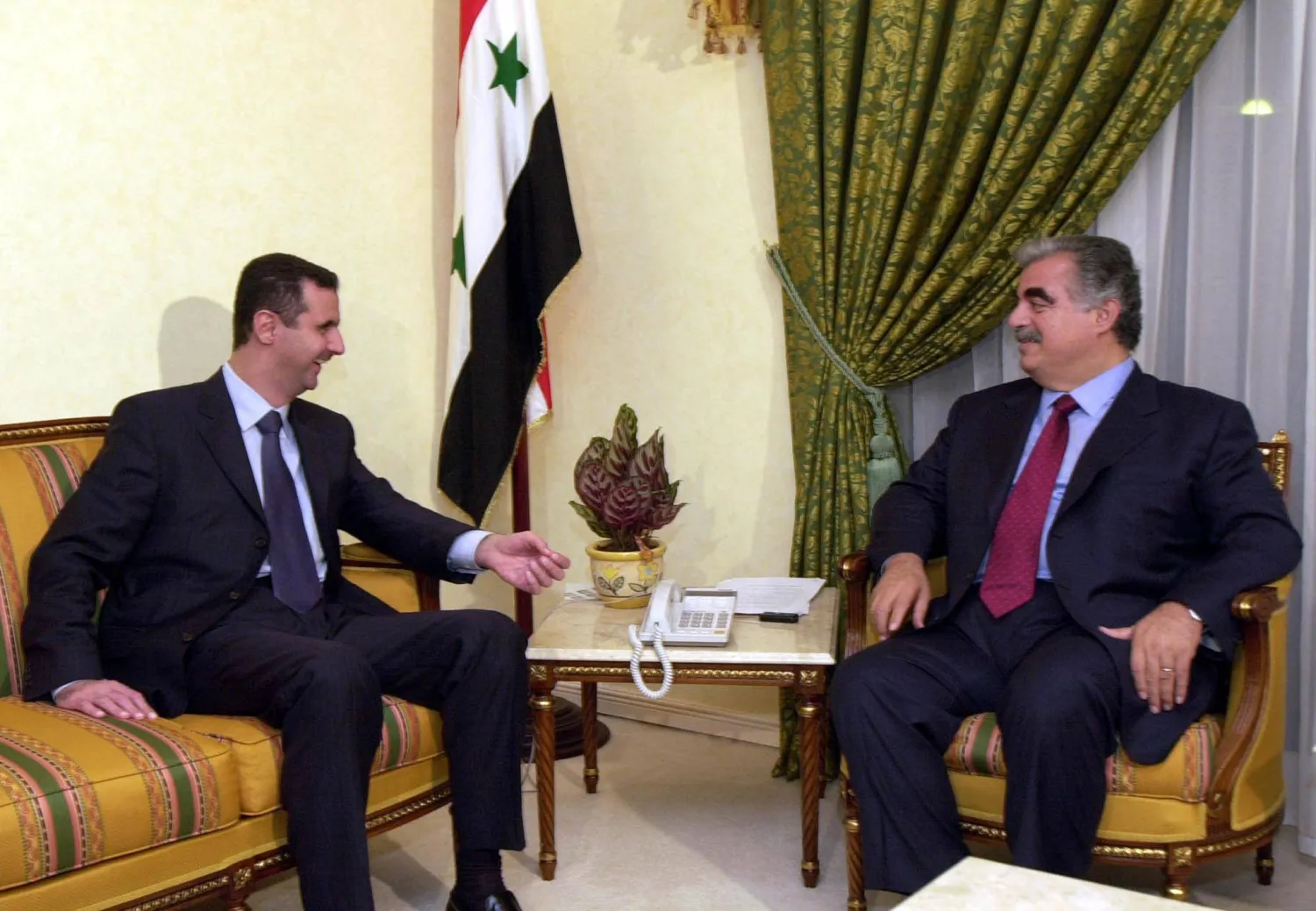 الرئيس الأسد مستقبلاً رفيق الحريري (غيتي)