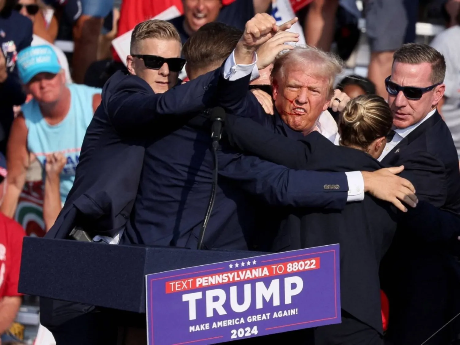 إجلاء ترمب من فوق المنصة بعد إصابته خلال التجمع الانتخابي في بنسيلفانيا بعد إطلاق النار عليه وإصابته في أذنه (أرشيفية - رويترز)