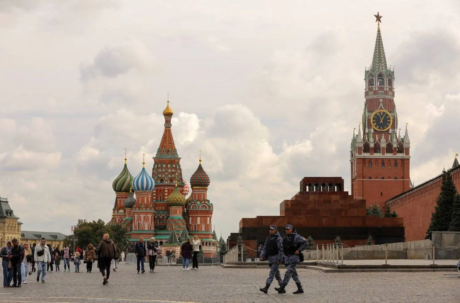 Moskova'nın merkezindeki Aziz Vasil Katedrali ve Kremlin'in Spasskaya Kulesi'nin yakınındaki Kızıl Meydan'da yürüyen insanlar (Reuters)
