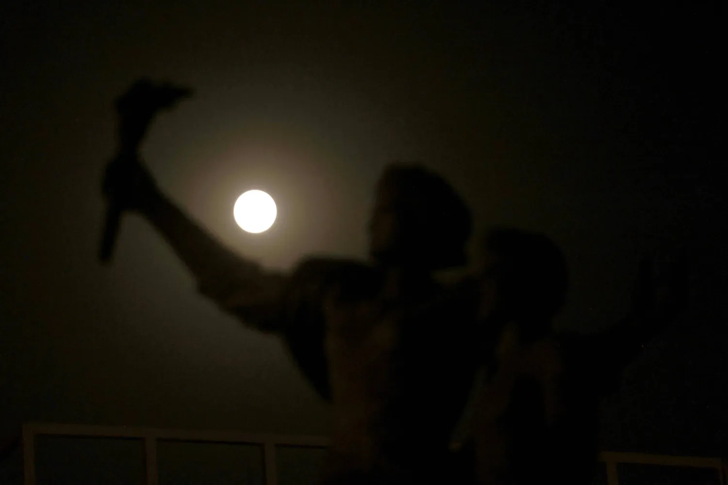 القمر الأزرق العملاق يرتفع خلف تمثال الشهداء التذكاري في العاصمة اللبنانية بيروت (أ.ف.ب)