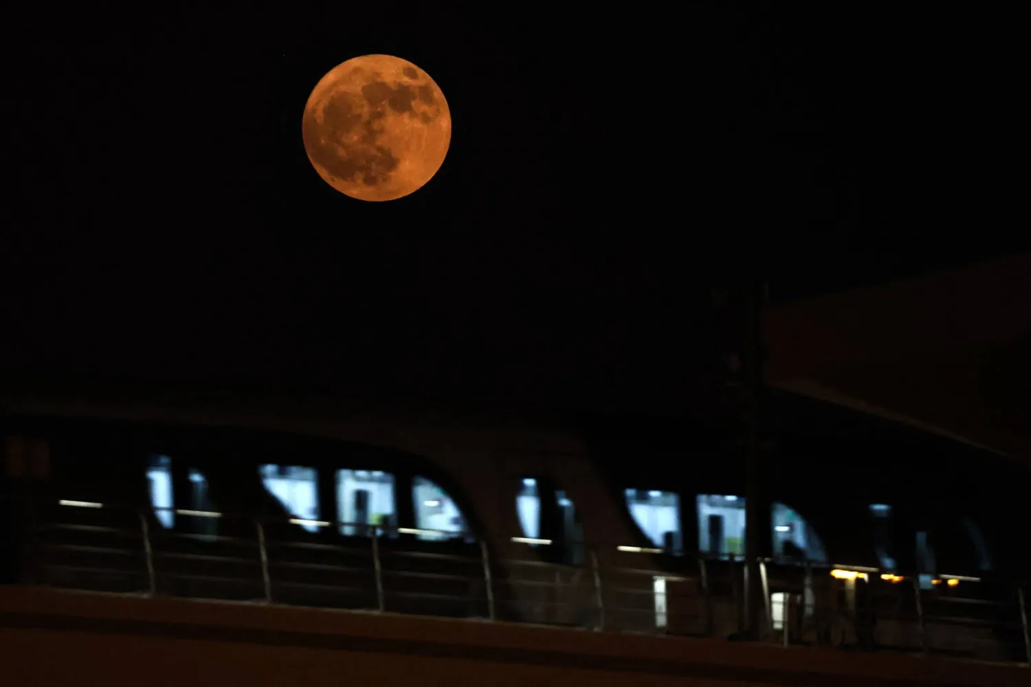 القمر العملاق يظهر خلف محطة مترو في العاصمة القطرية الدوحة (أ.ف.ب)