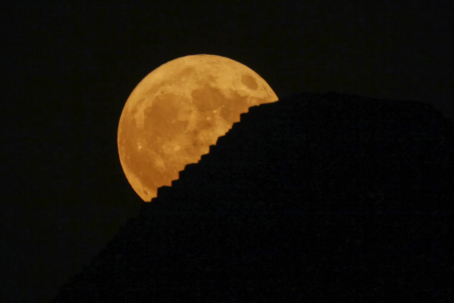 القمر العملاق يرتفع خلف أهرامات الجيزة في مصر (أ.ب)