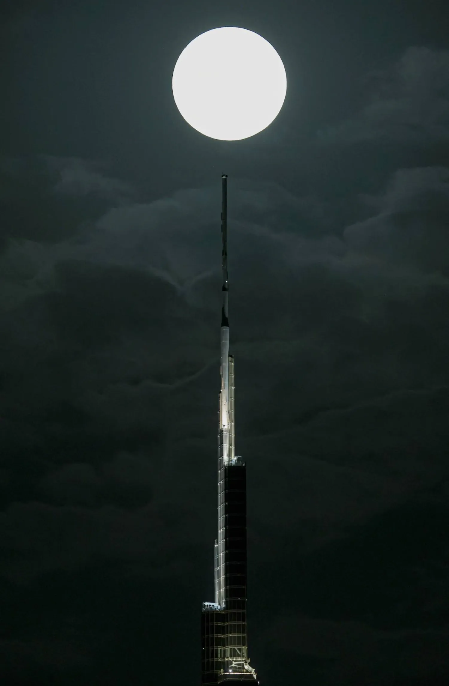 القمر الأزرق العملاق يرتفع فوق برج خليفة في دبي بالإمارات العربية المتحدة (إ.ب.أ)