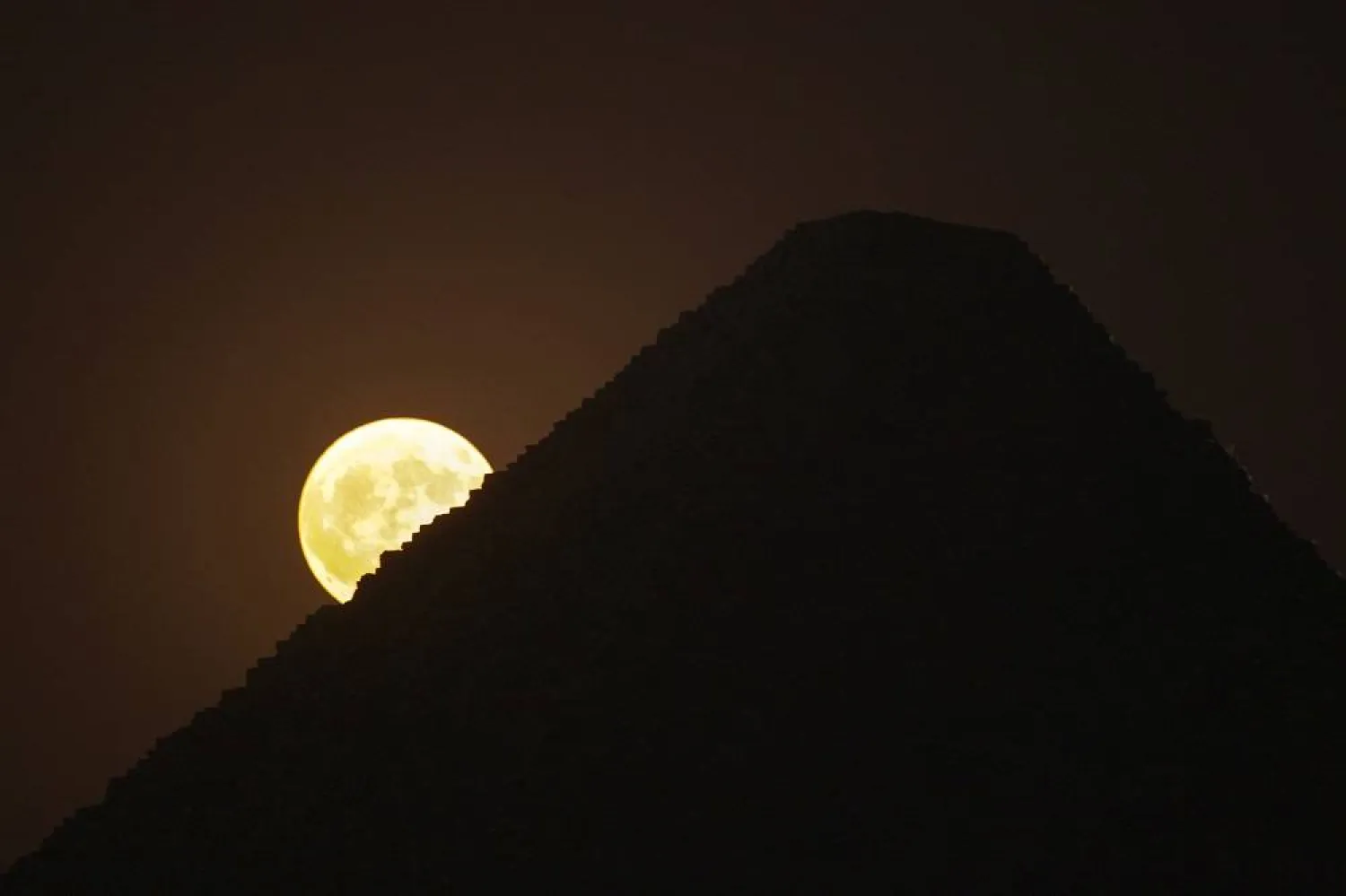 The supermoon rises behind the historical site of Giza Pyramids, near Cairo, Egypt, Monday, Aug. 19, 2024. (AP)