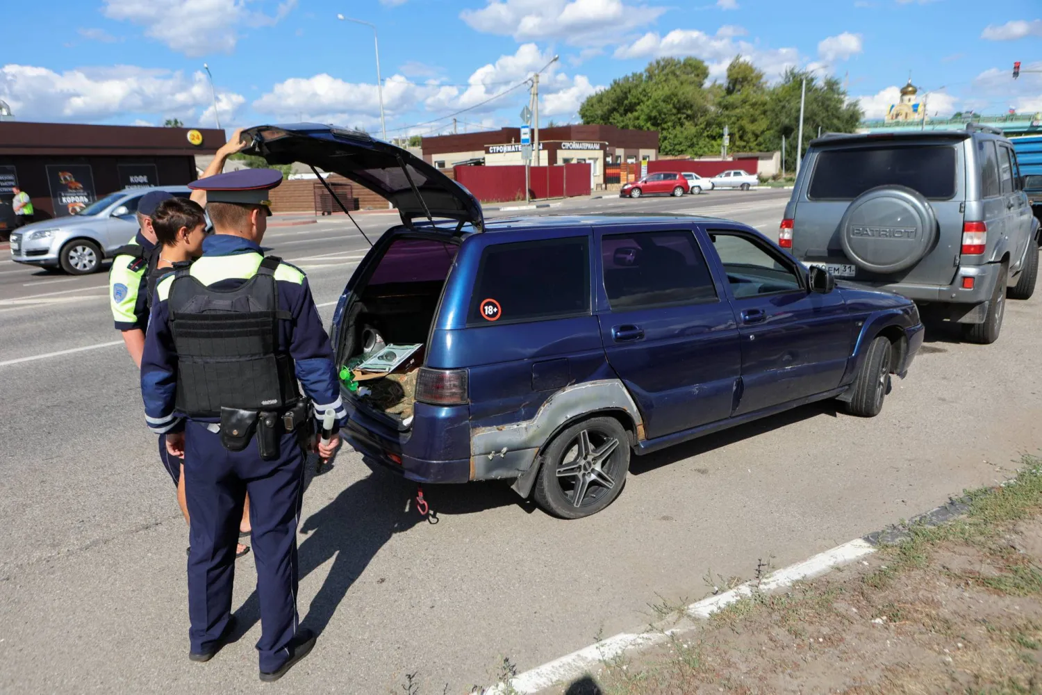 عناصر من الشرطة الروسية يدققون بسيارة عند نقطة تفتيش في بيلغورود (رويترز)