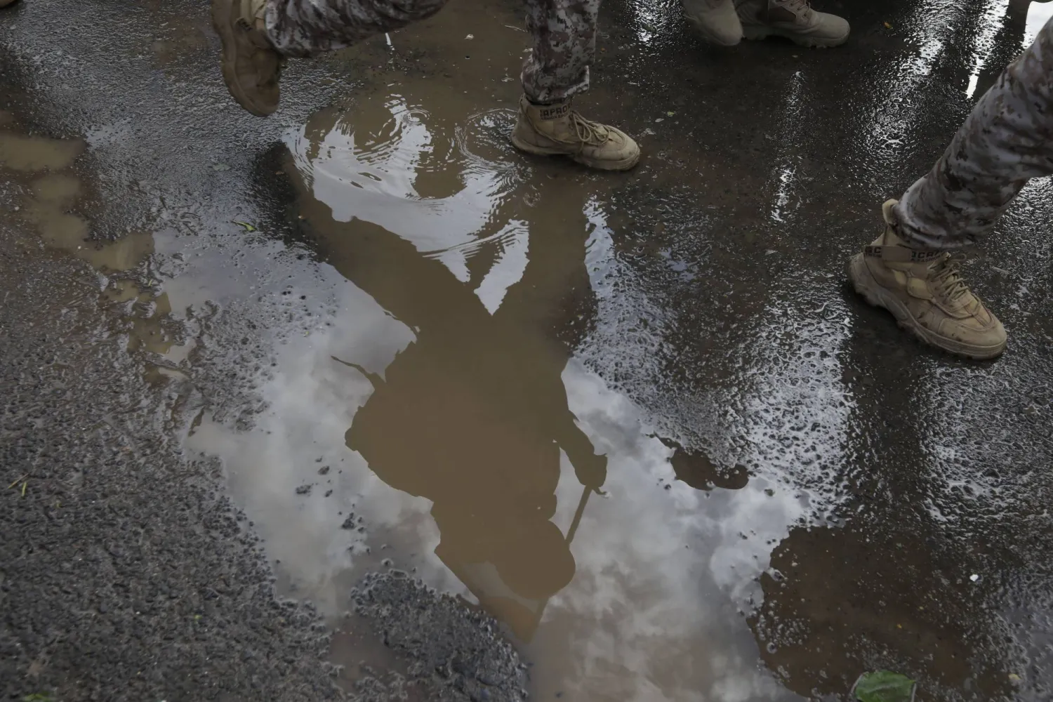 A Houthi soldier is seen walking in a puddle of water while marching during an anti-US and Israel protest, in Sanaa, Yemen, 16 August 2024. EPA/YAHYA ARHAB  EPA-EFE/YAHYA ARHAB