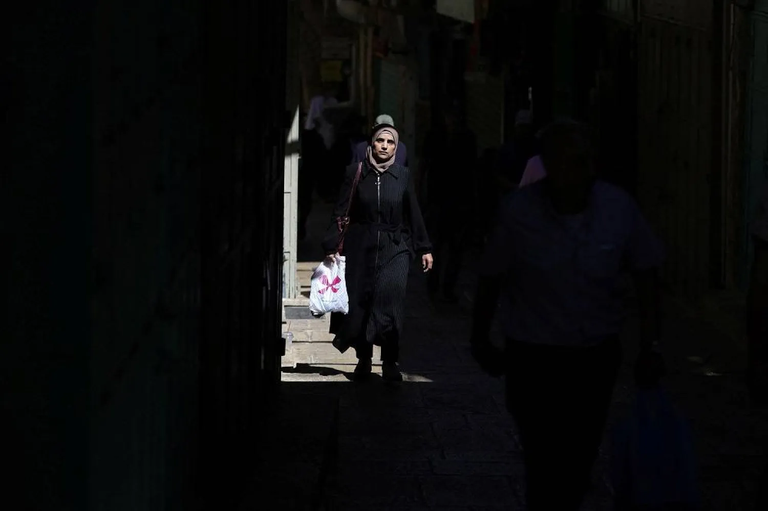 A woman walks near a market in Jerusalem's Old City, August 16, 2024. (Reuters)