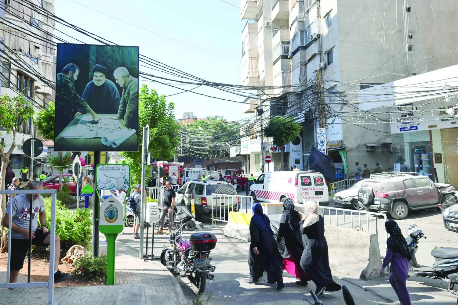 سكان من الضاحية الجنوبية لبيروت يعبرون شارعاً في حارة حريك على مقربة من موقع استهداف القيادي بـ«حزب الله» فؤاد شكر (أ.ف.ب)