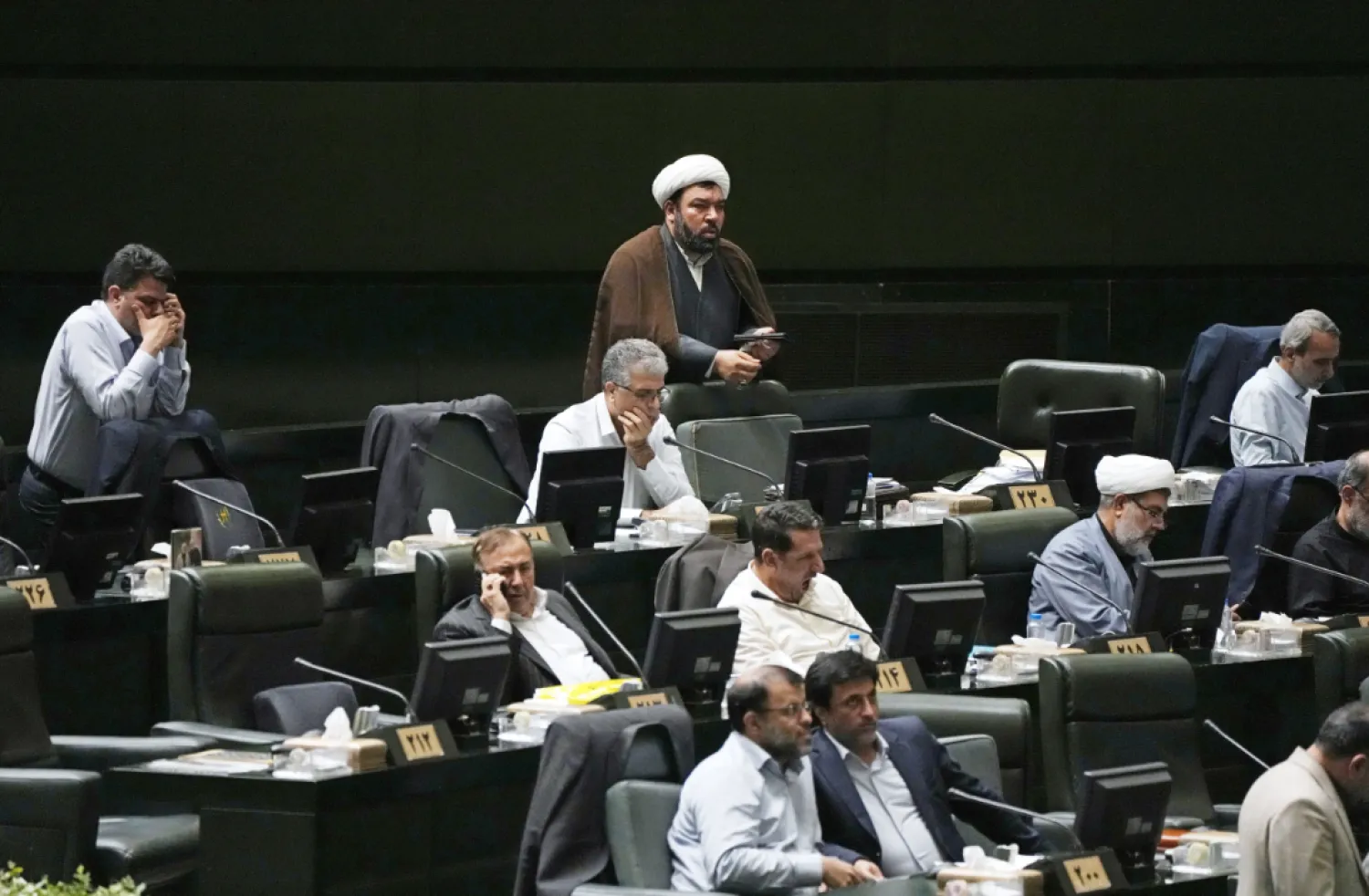 Iranian lawmakers attend an open session of parliament during the third day of debate on the 19 proposed ministers by President Masoud Pezeshkian, in Tehran, Iran, Monday, Aug. 19, 2024. (AP Photo/Vahid Salemi)