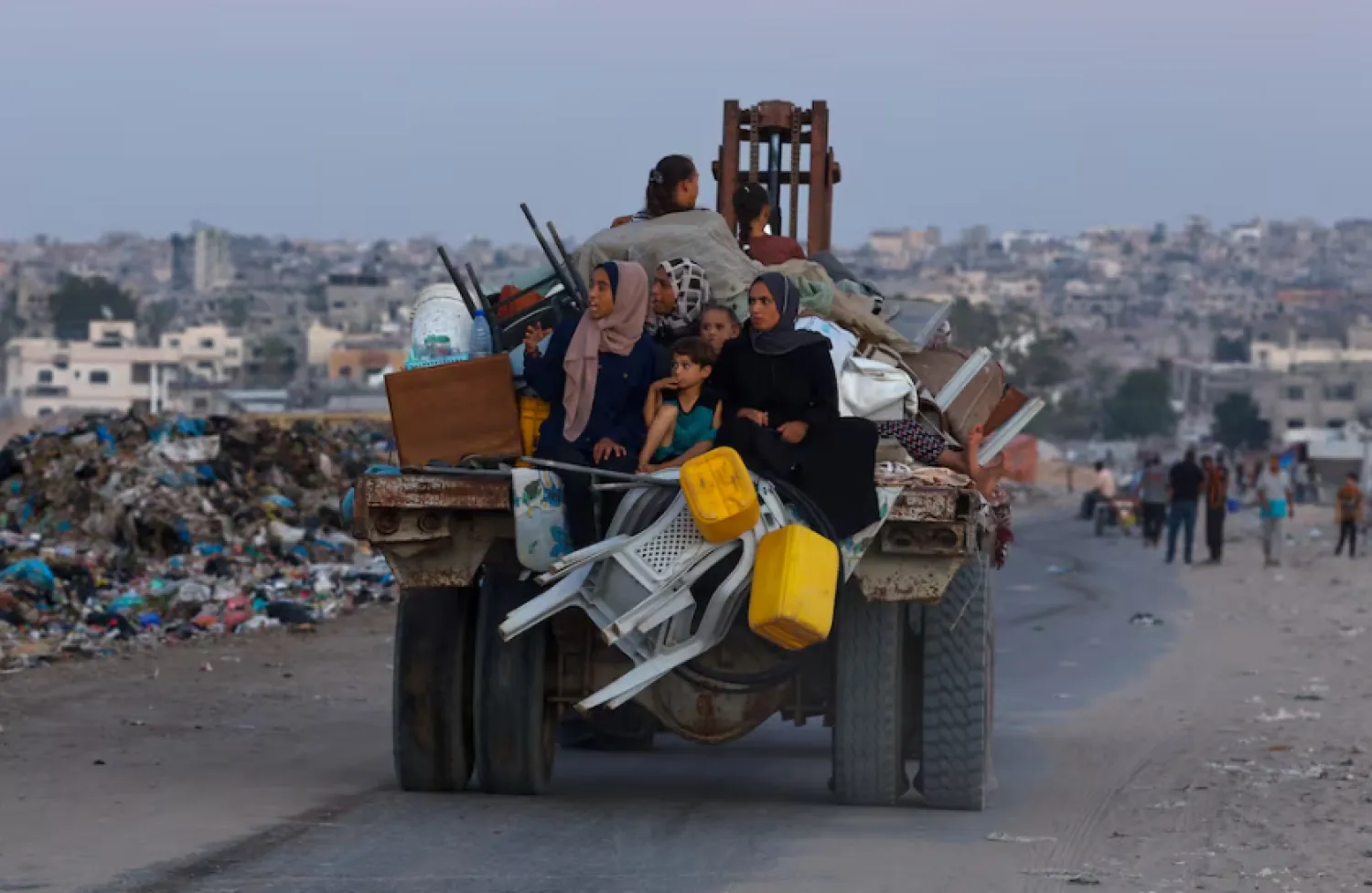 Displaced Palestinians travel on a cart after fleeing the western part of Khan Younis, following an evacuation order by the Israeli army, amid Israel- Hams conflict, in the central part of Khan Younis, in the southern Gaza Strip, August 21, 2024. REUTERS/Mohammed Salem Purchase Licensing Rights