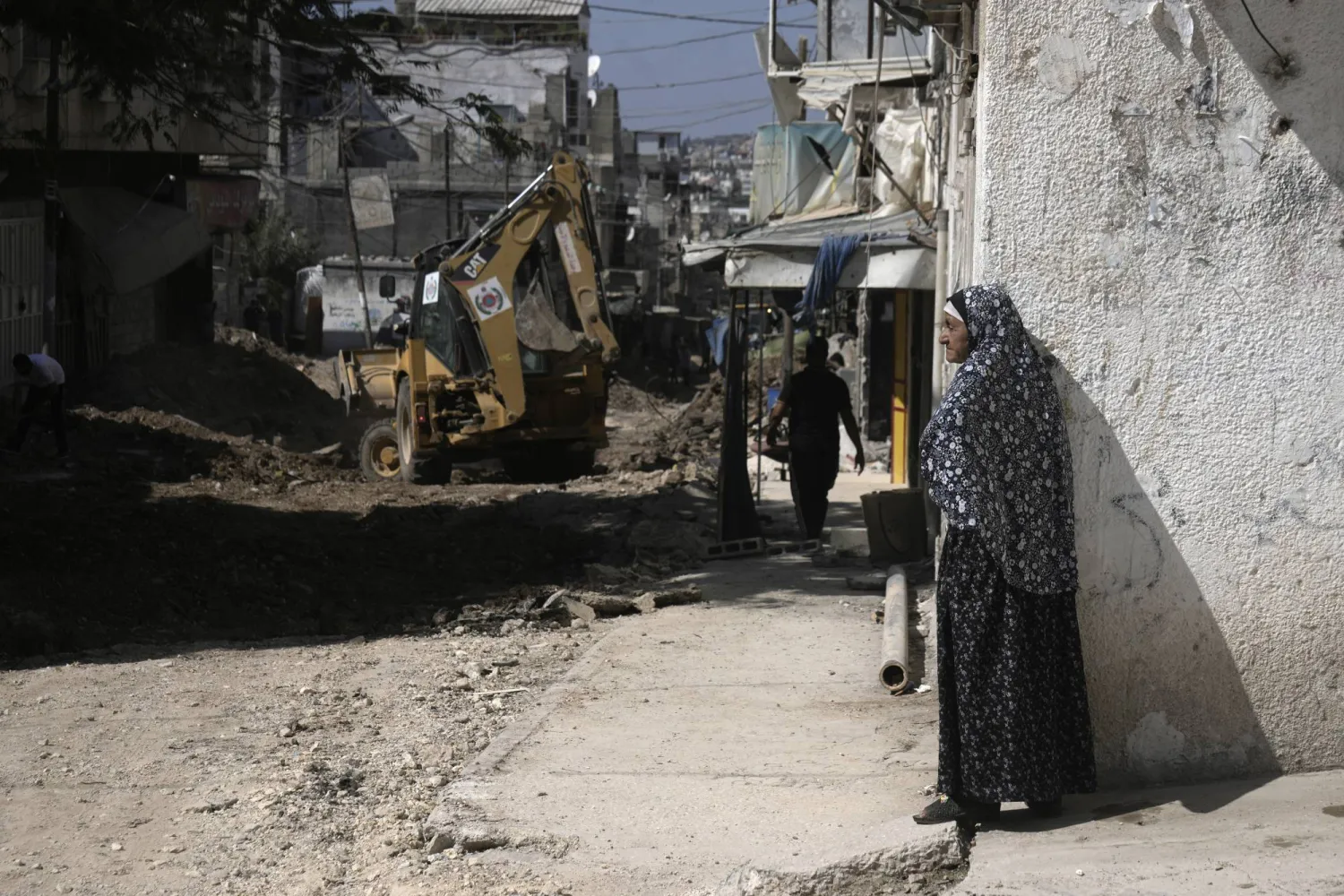 A Palestinian woman watches an operation by the Israeli military in Tulkarem refugee camp in the West Bank, Saturday, Aug. 3, 2024. (AP Photo/Majdi Mohammed)